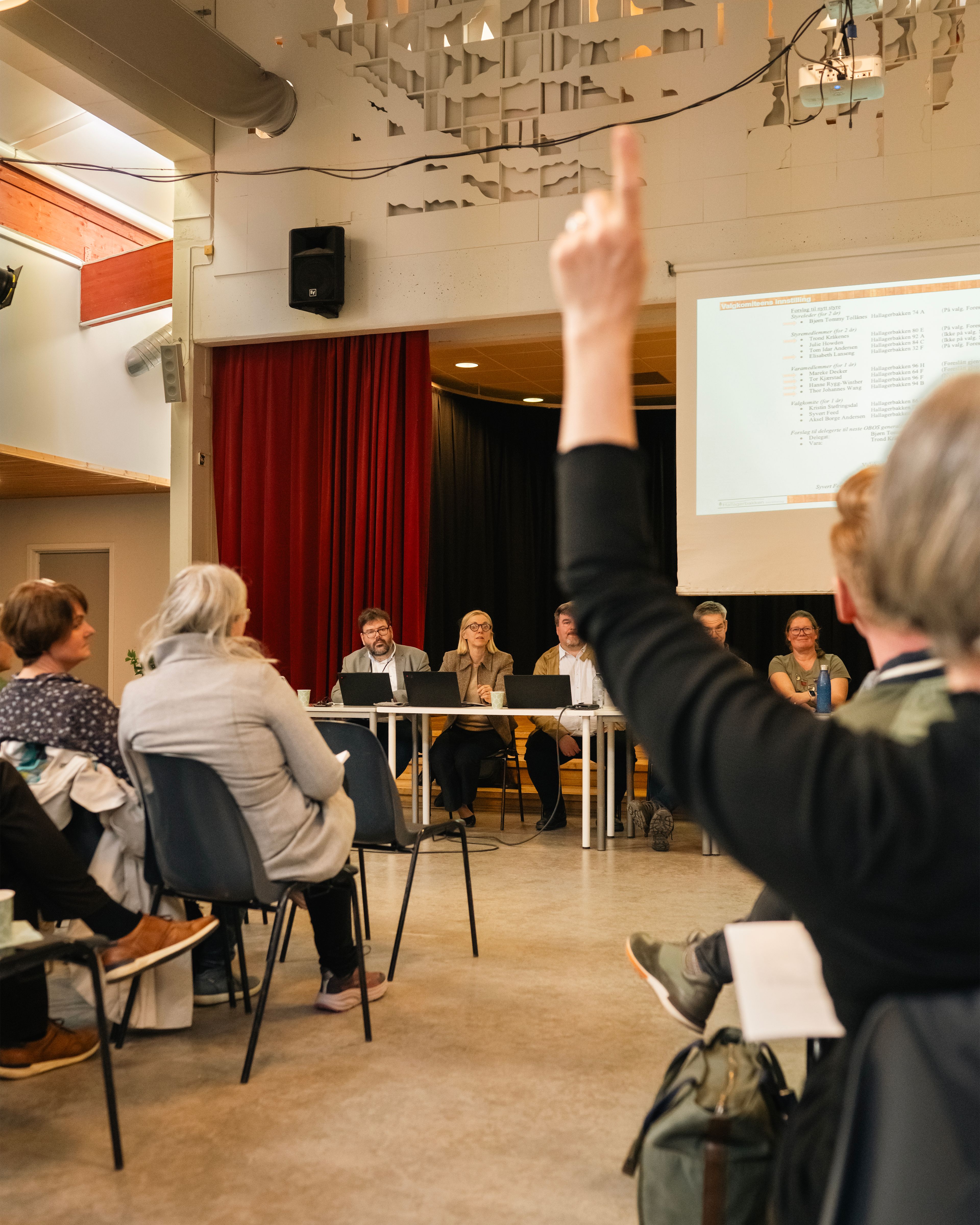 Det er generalforsamling, og en person rekker opp hånda.