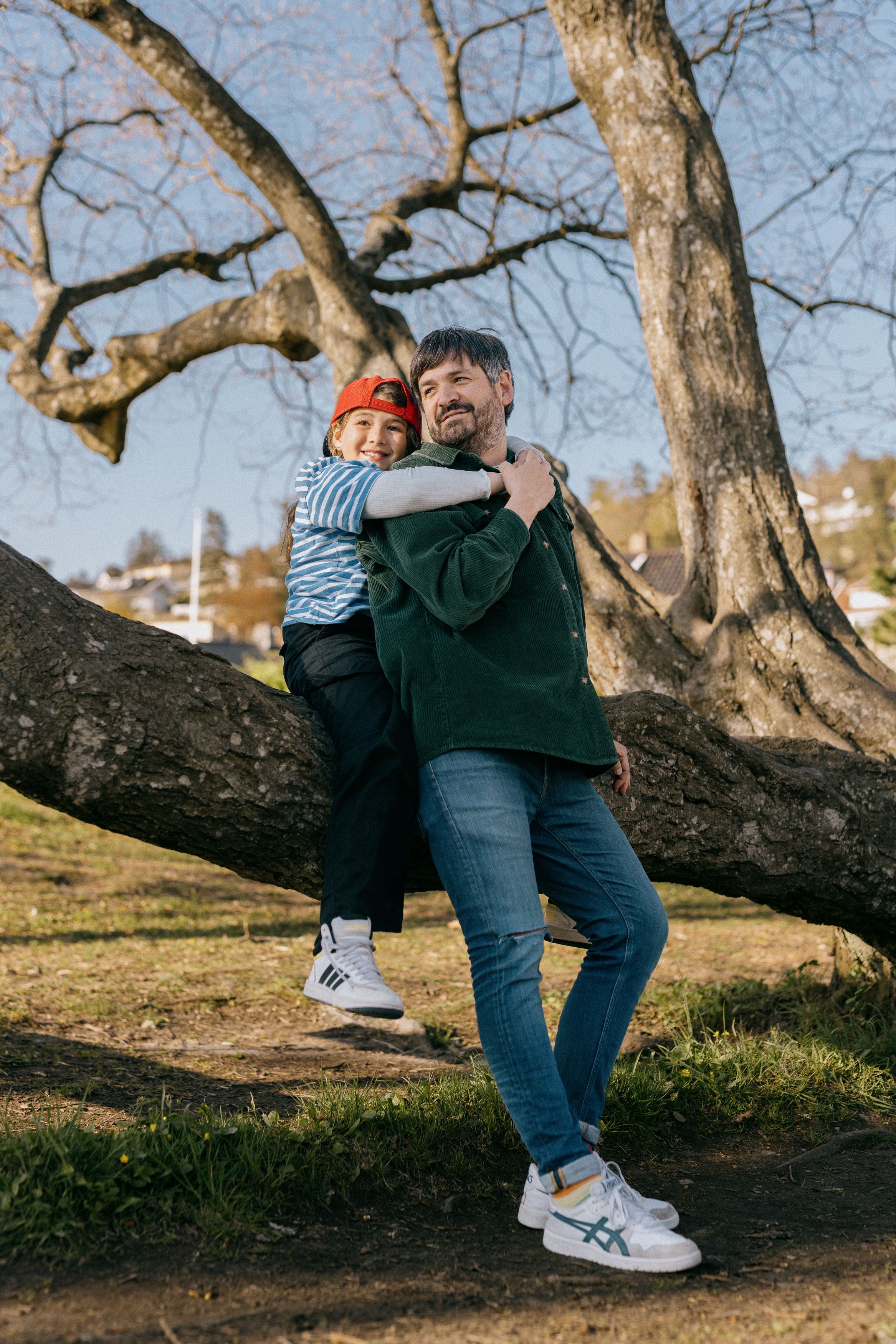 Mann poserer ved et tre sammen med datteren din.