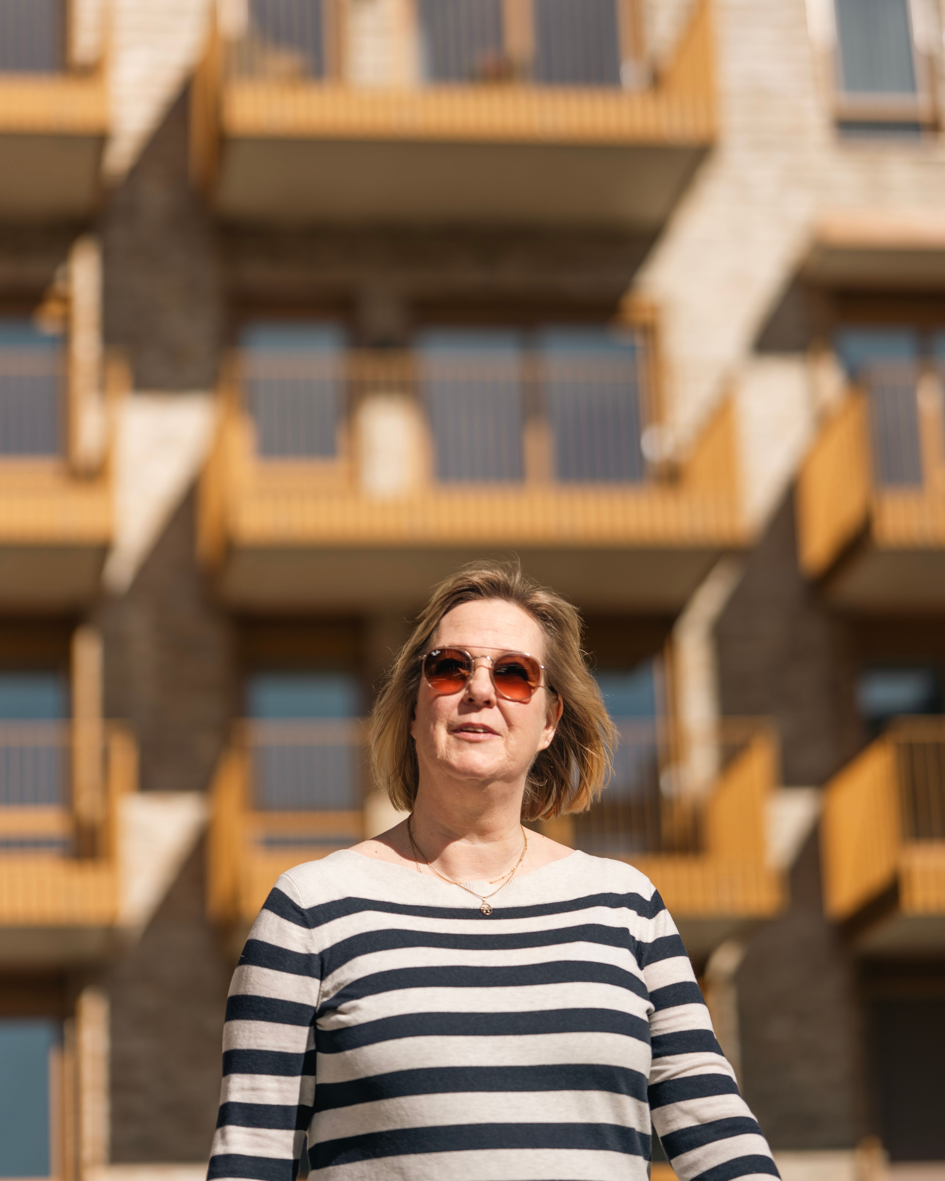 Bildet av Helene Østrem med en blokk fra Kvarteret i bakgrunnen.