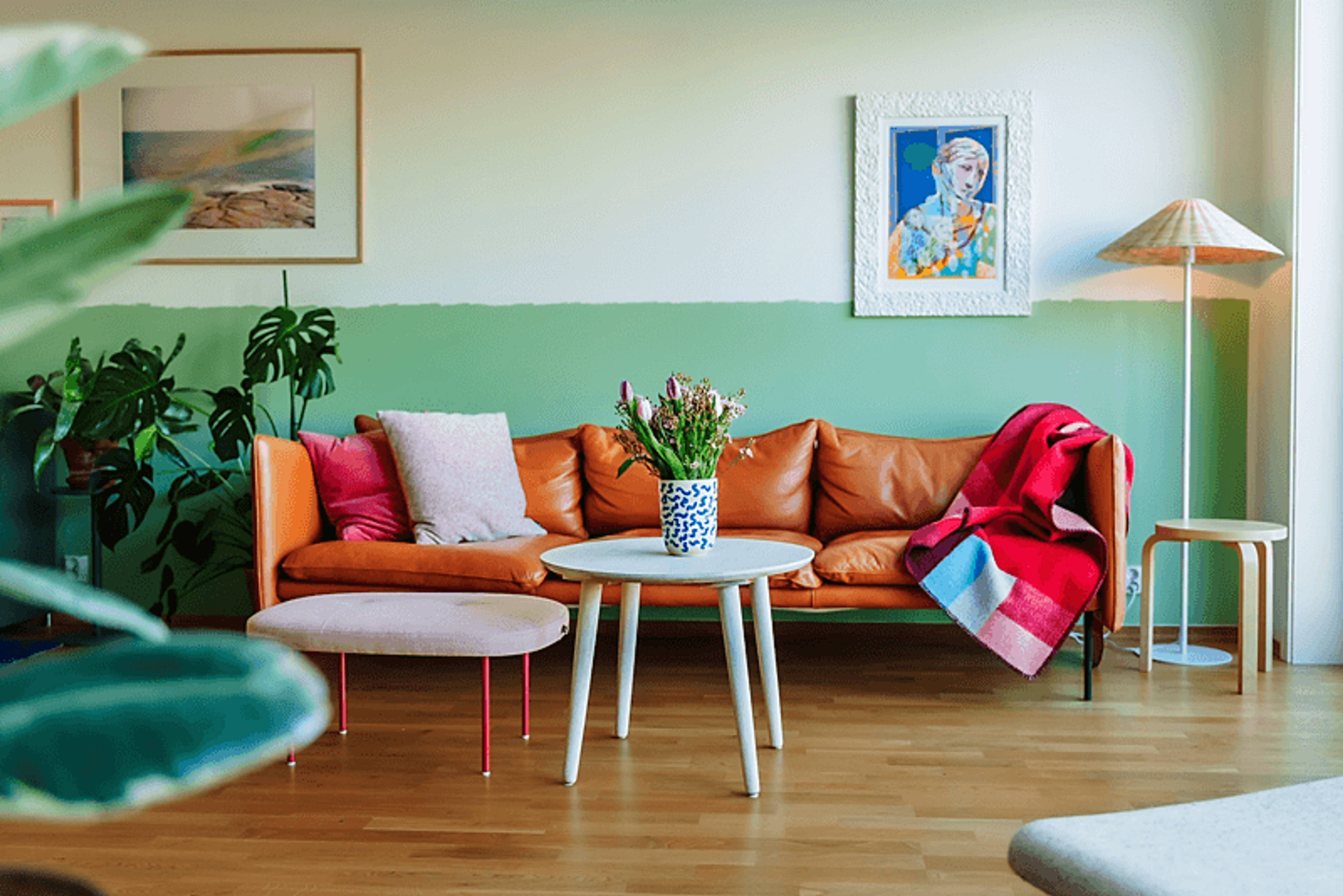 Oversiktsbilde av stua til Ane som viser den oransje sofaen og den tofargede veggen