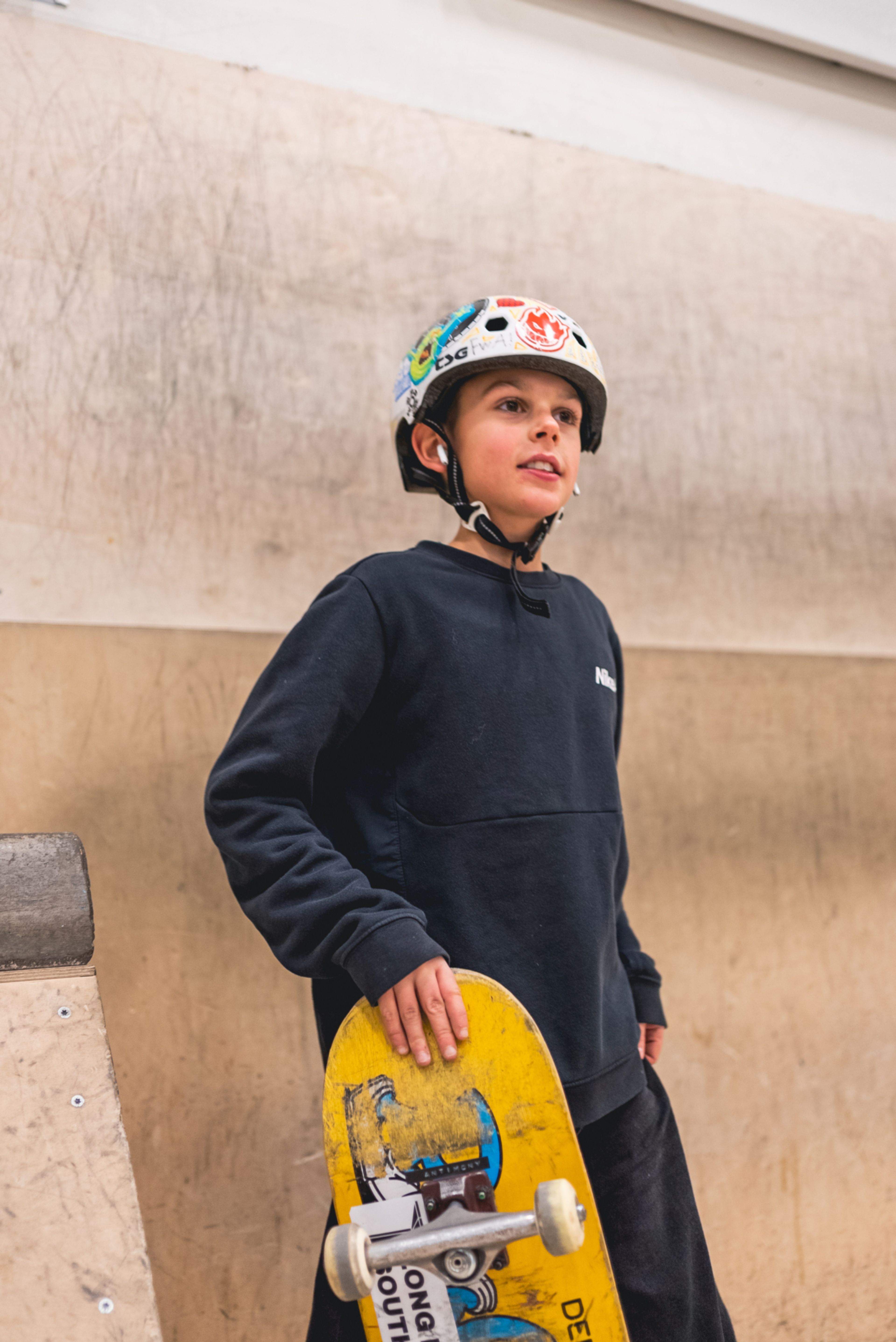 Foto av en gutt som holder skateboardet sitt og mens han ser utover Oslo Skatehatt