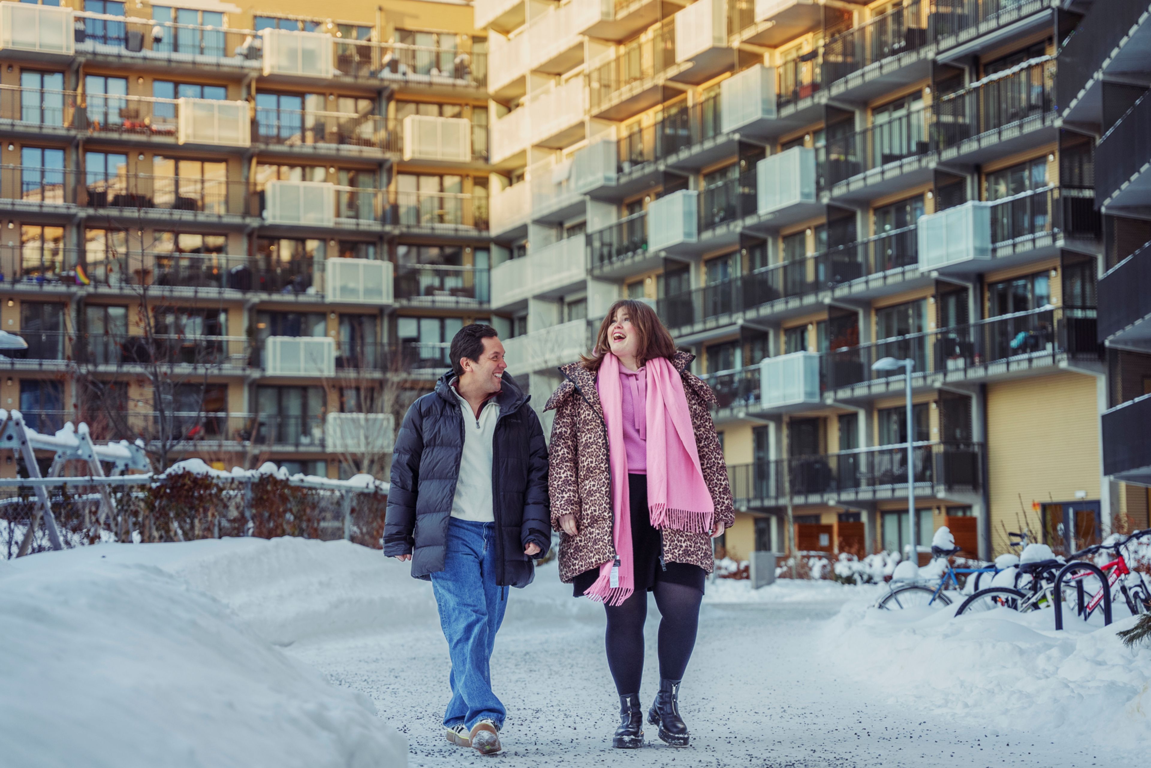 To venner som går sammen gjennom et gårdsrom i et borettslag på Ulven