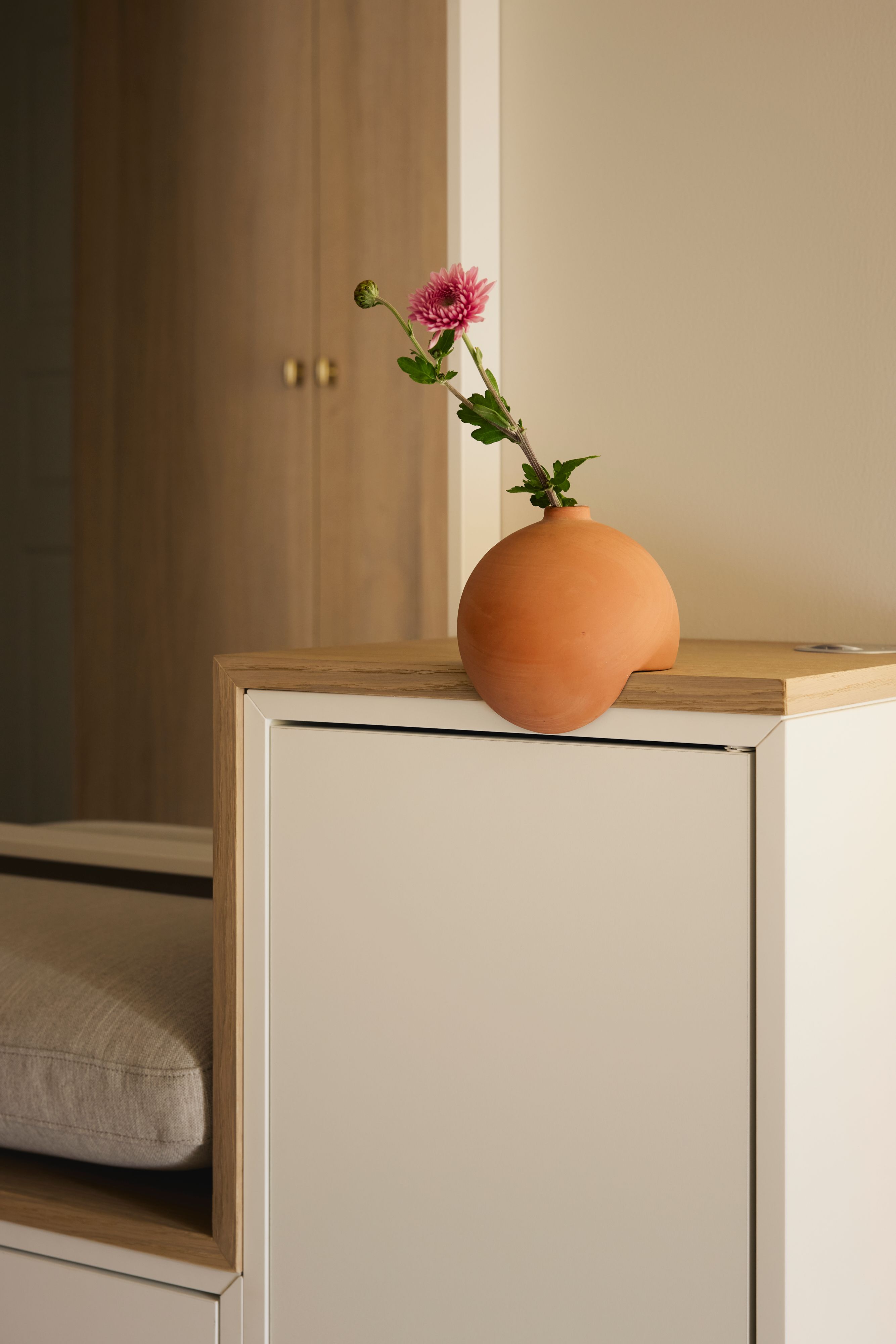 Et detaljbilde fra gangen med praktiske sittemøbler.