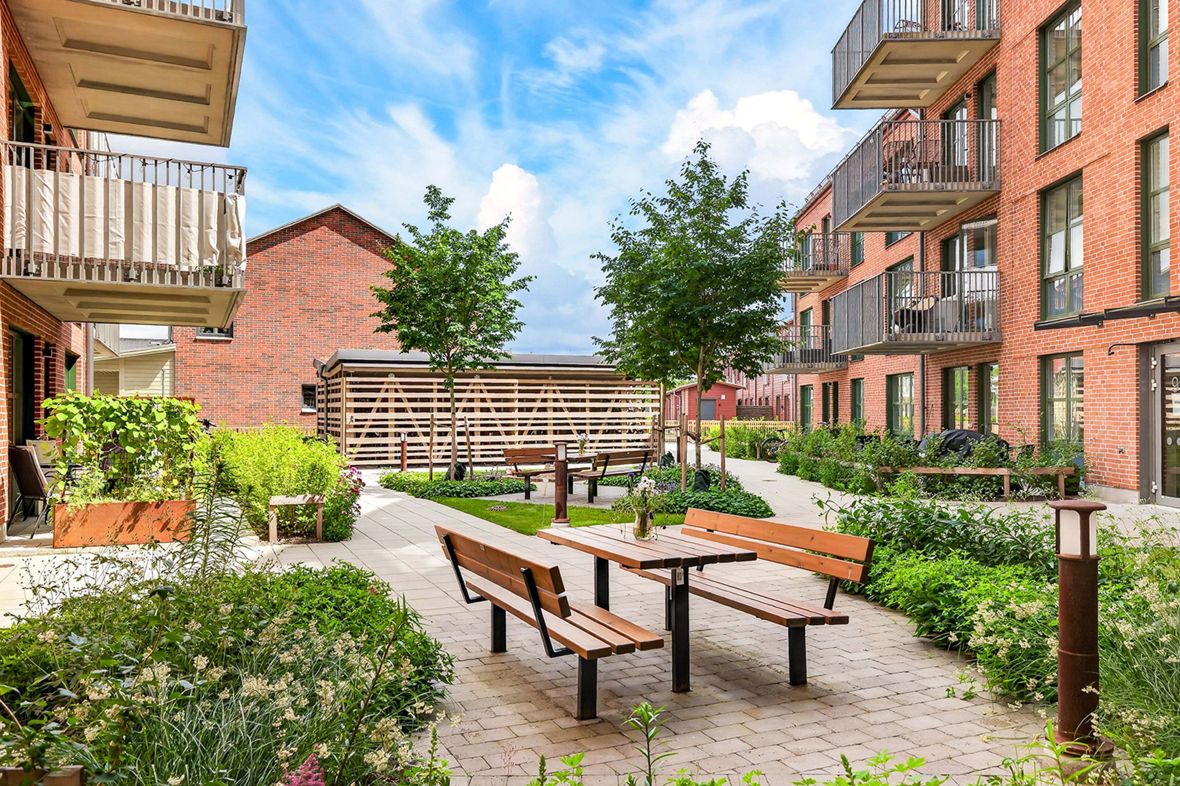 Foto på grönskande innergård med sittplatser