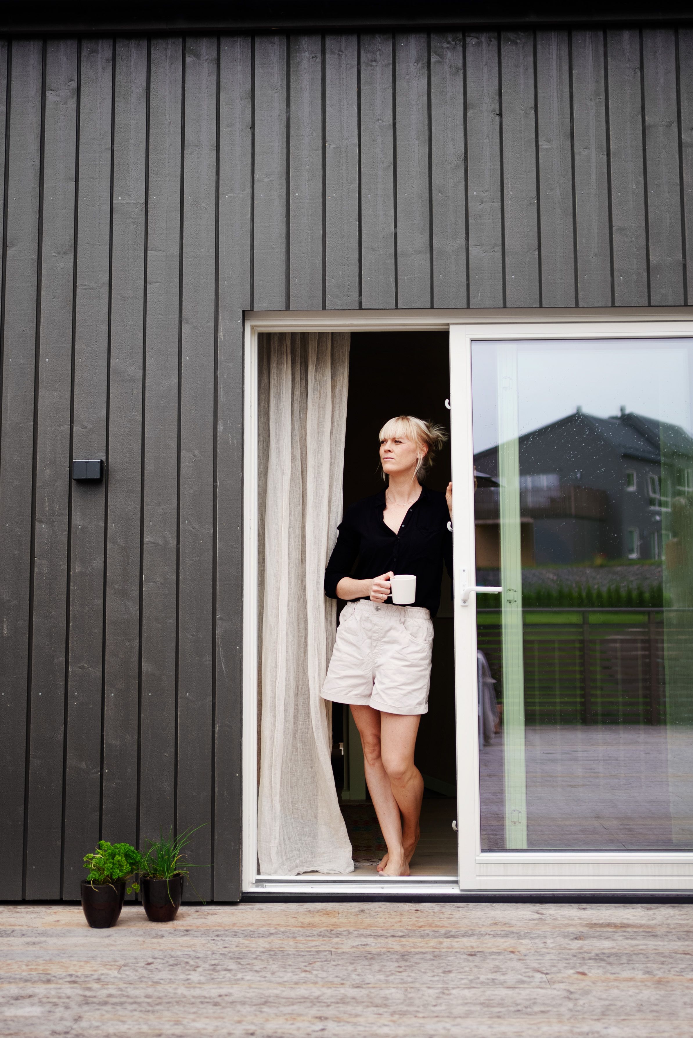 Susanne står i døråpningen ut til terrassen.