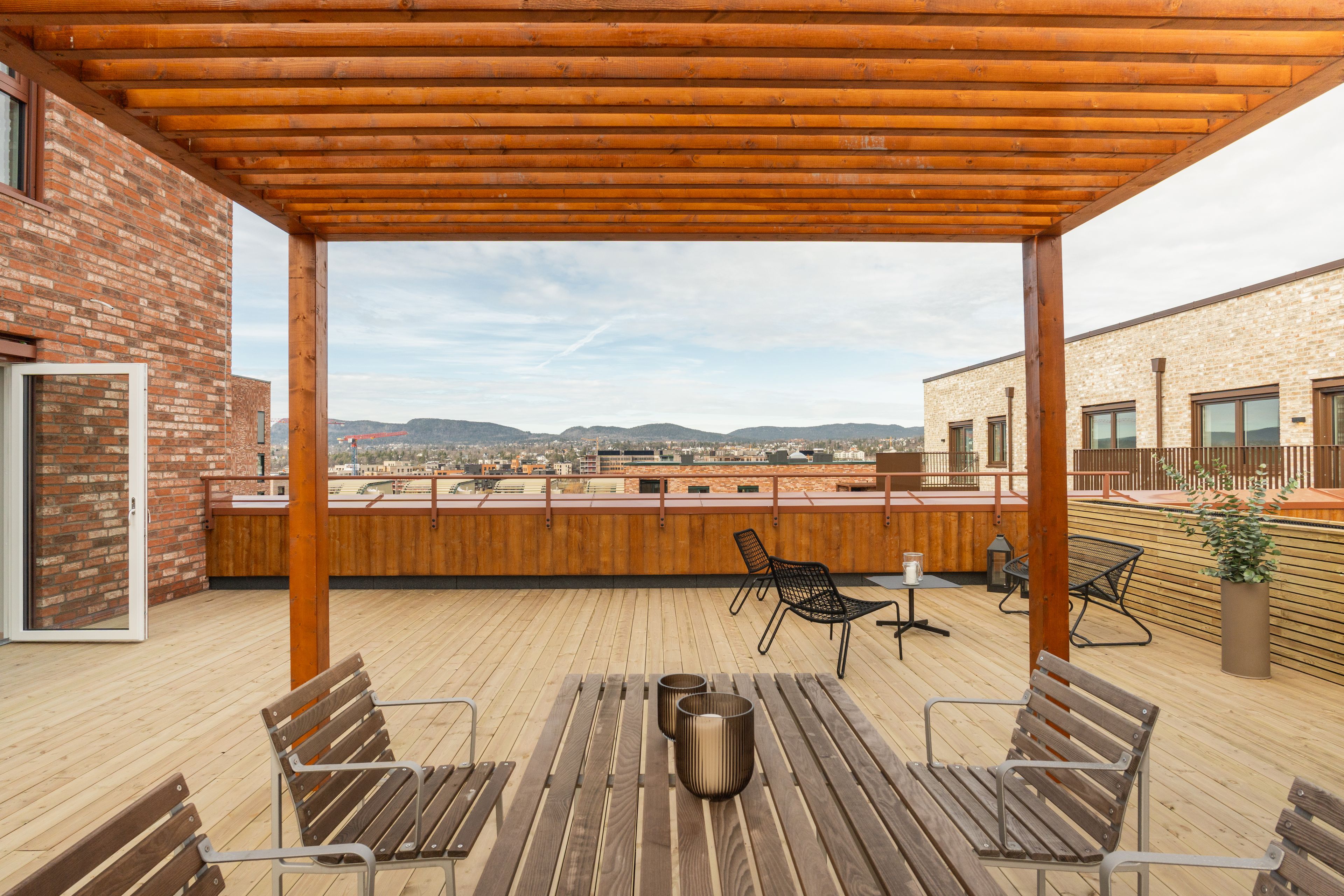 Privat takterrasse med pergola og sittegruppe.
