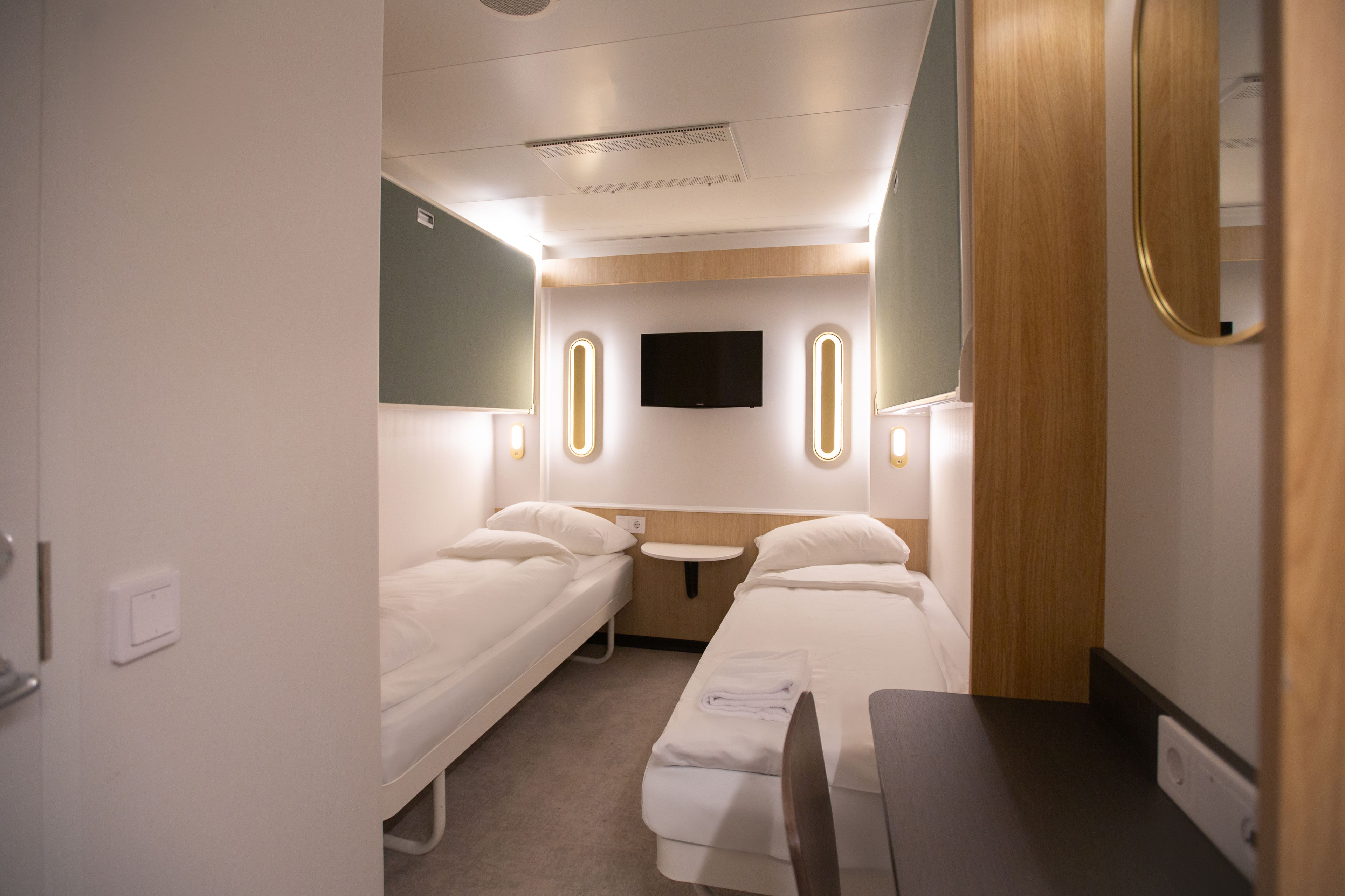 Nye standard lugarer Go Nordic Cruiseline. To senger på hver sin side av rommet. Grønt på veggene.