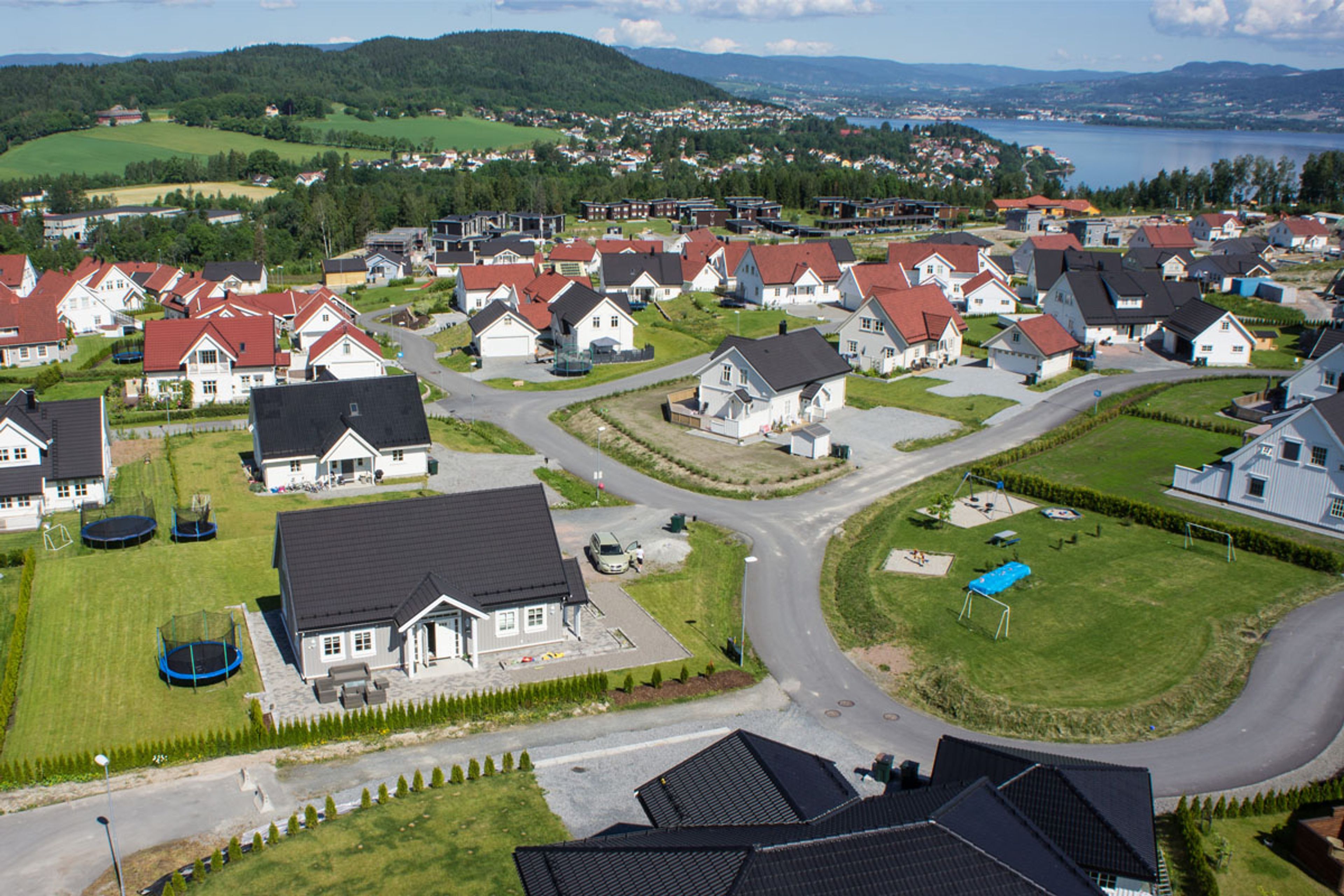 Dronefoto av flere OBOS Block Watne-eneboliger i et boligområde.