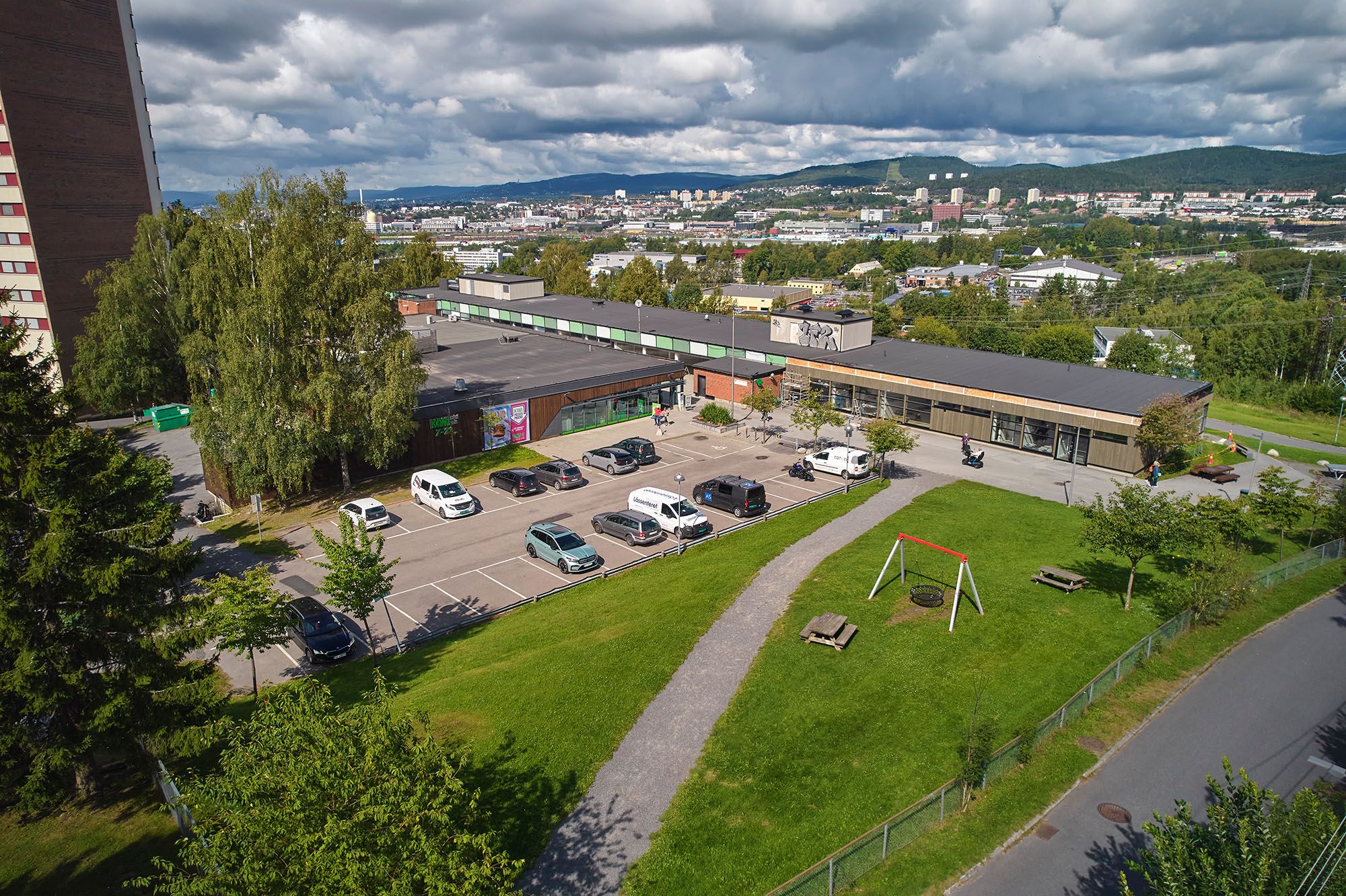 Dronefoto av hele Trosterud Torg med tilhørende parkeringsplass.