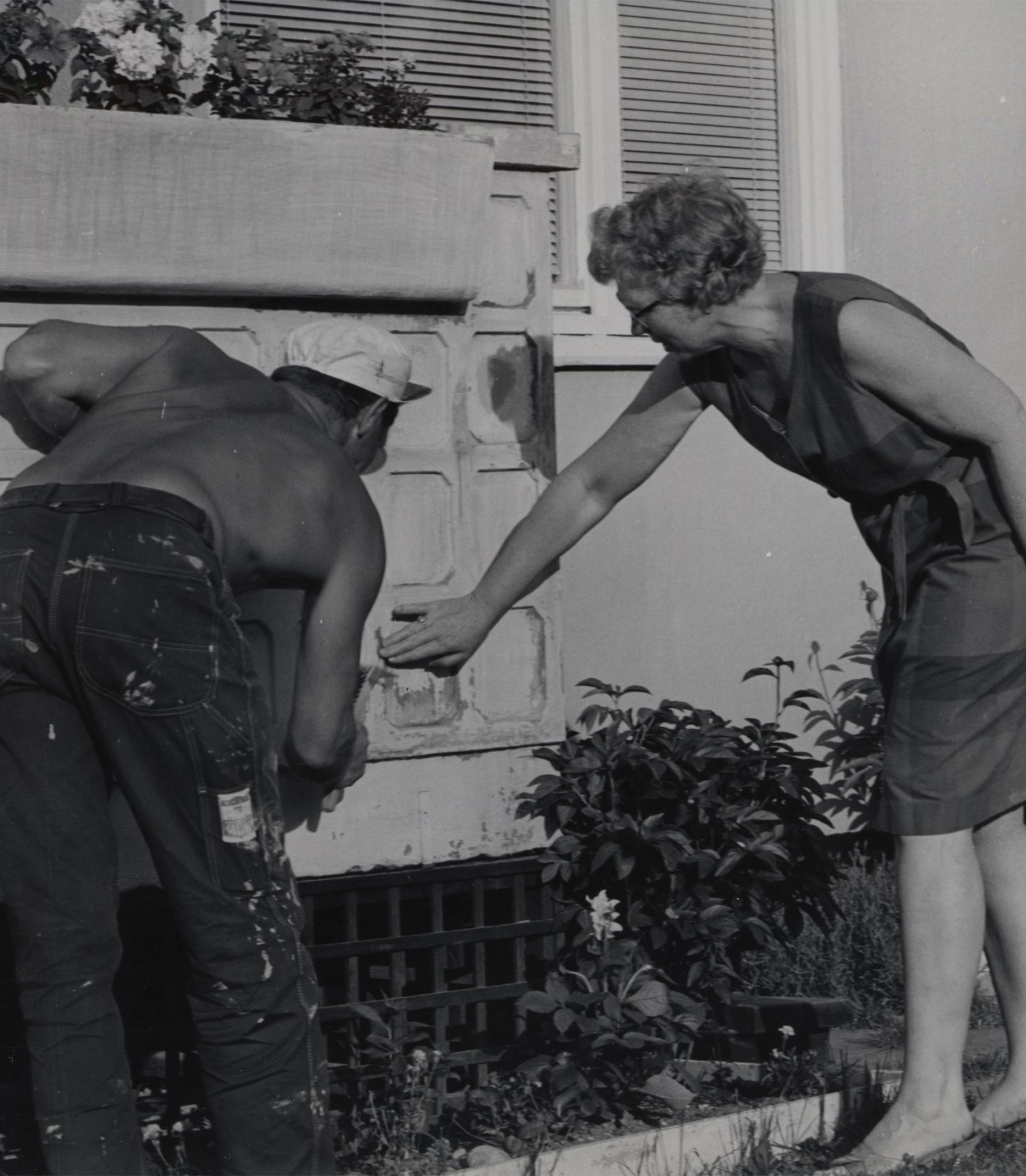 En mann og ei dame maler grunnmuren.