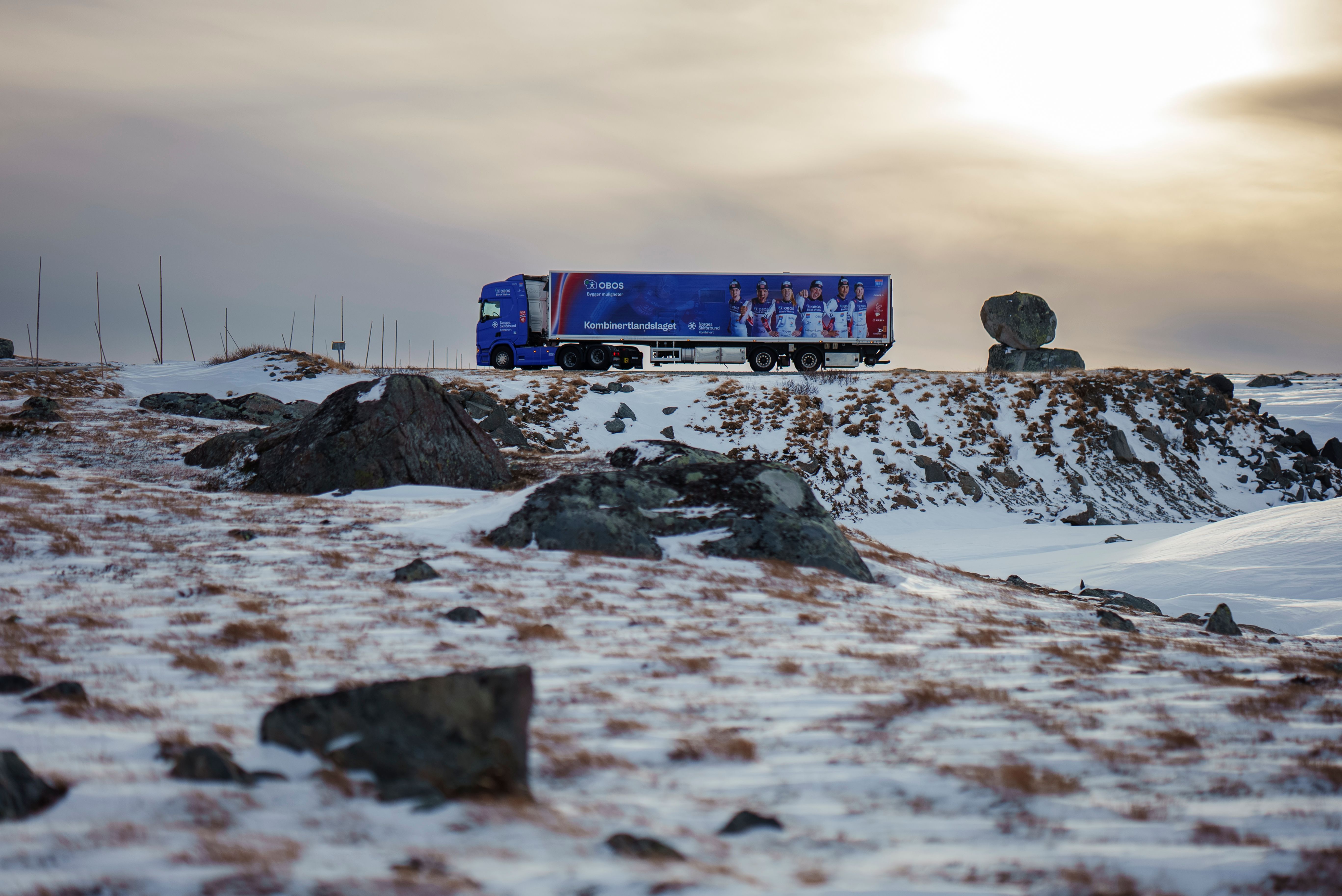 Smøretraileren til kombinertlandslaget parkert ved en landevei med snø og skumring