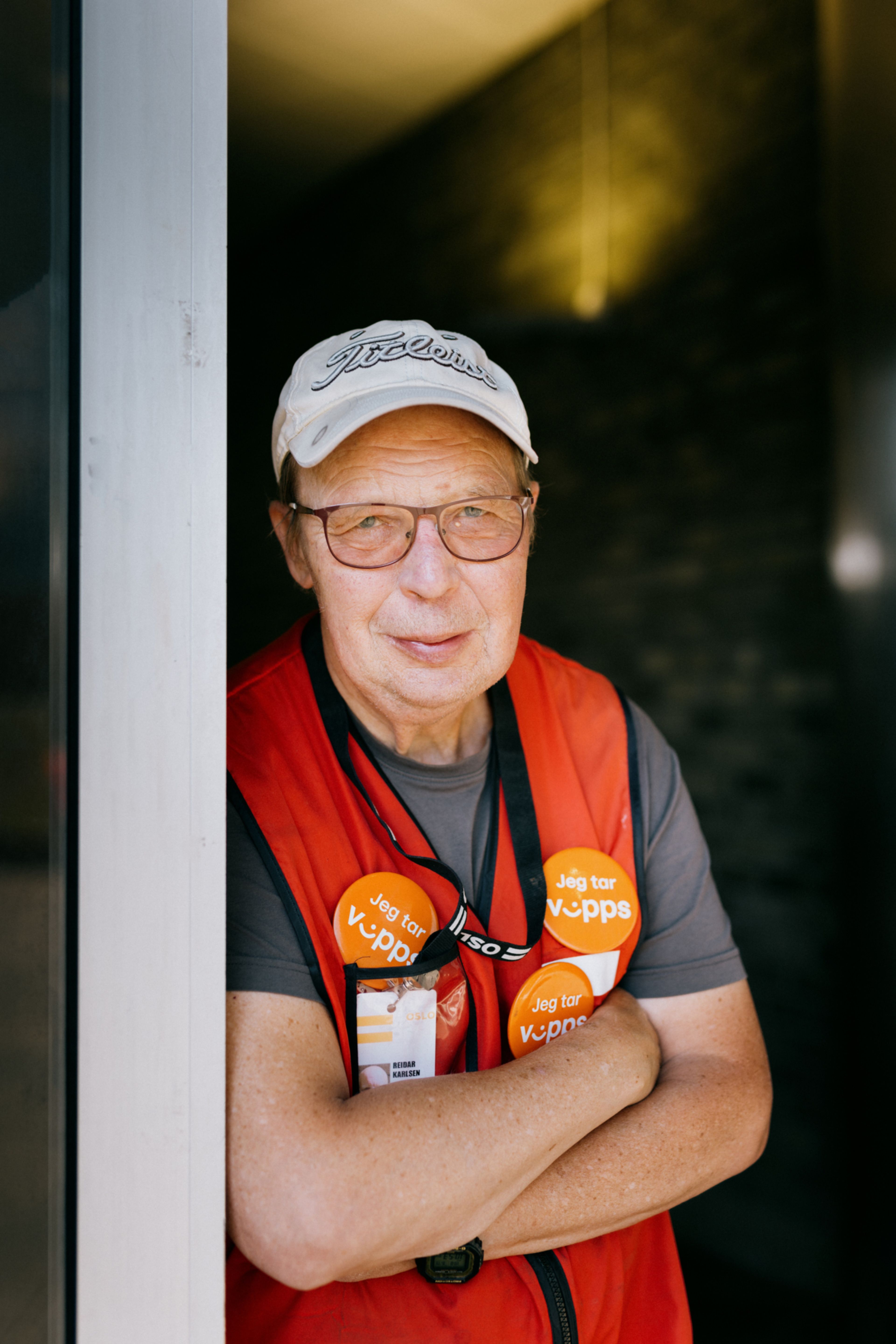 Portrett av Reidar som lener seg mot en av inngangsdørene på Tveita Senter.