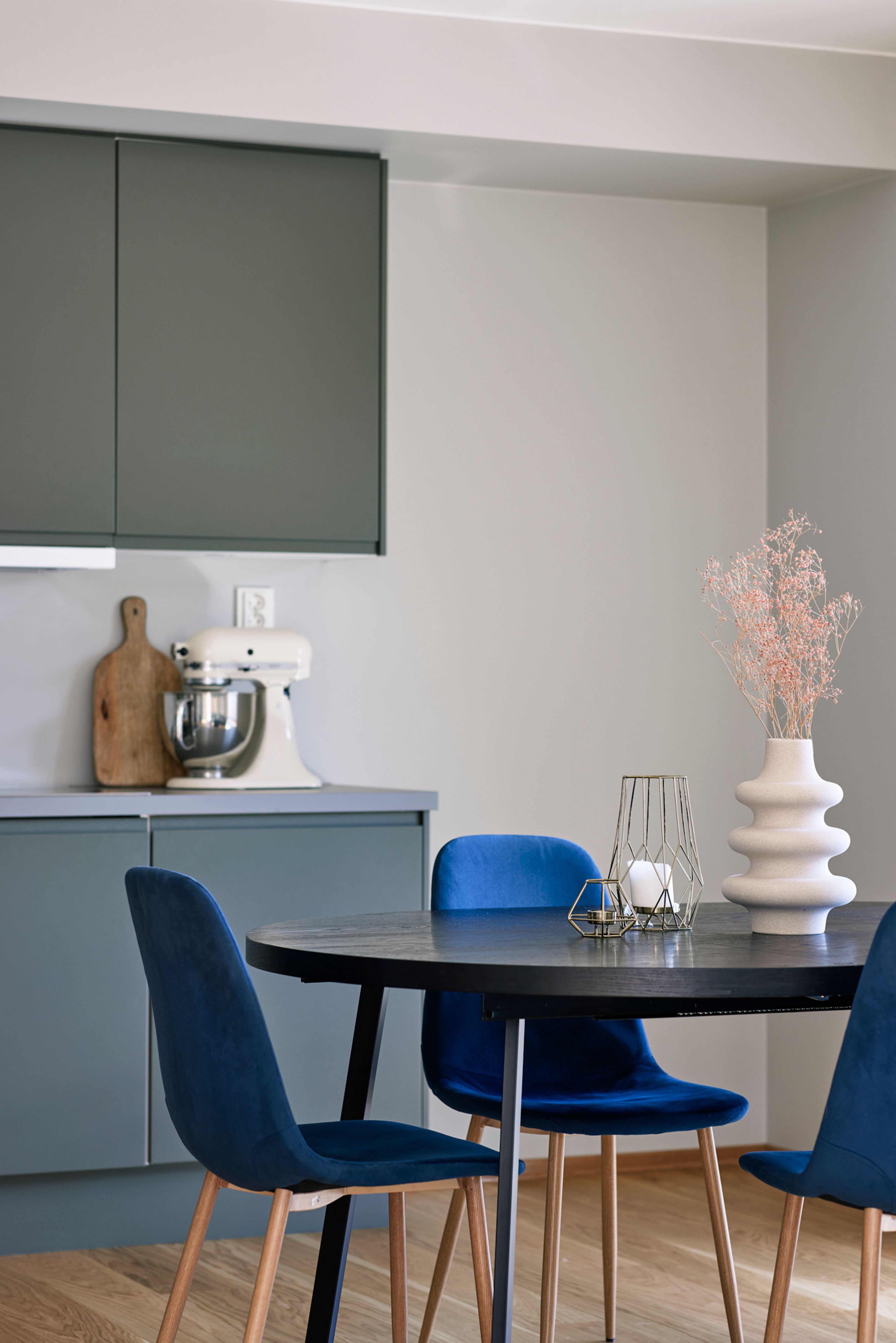 Deler av kjøkkenet i bakgrunnen med spisestuen i forgrunnen.