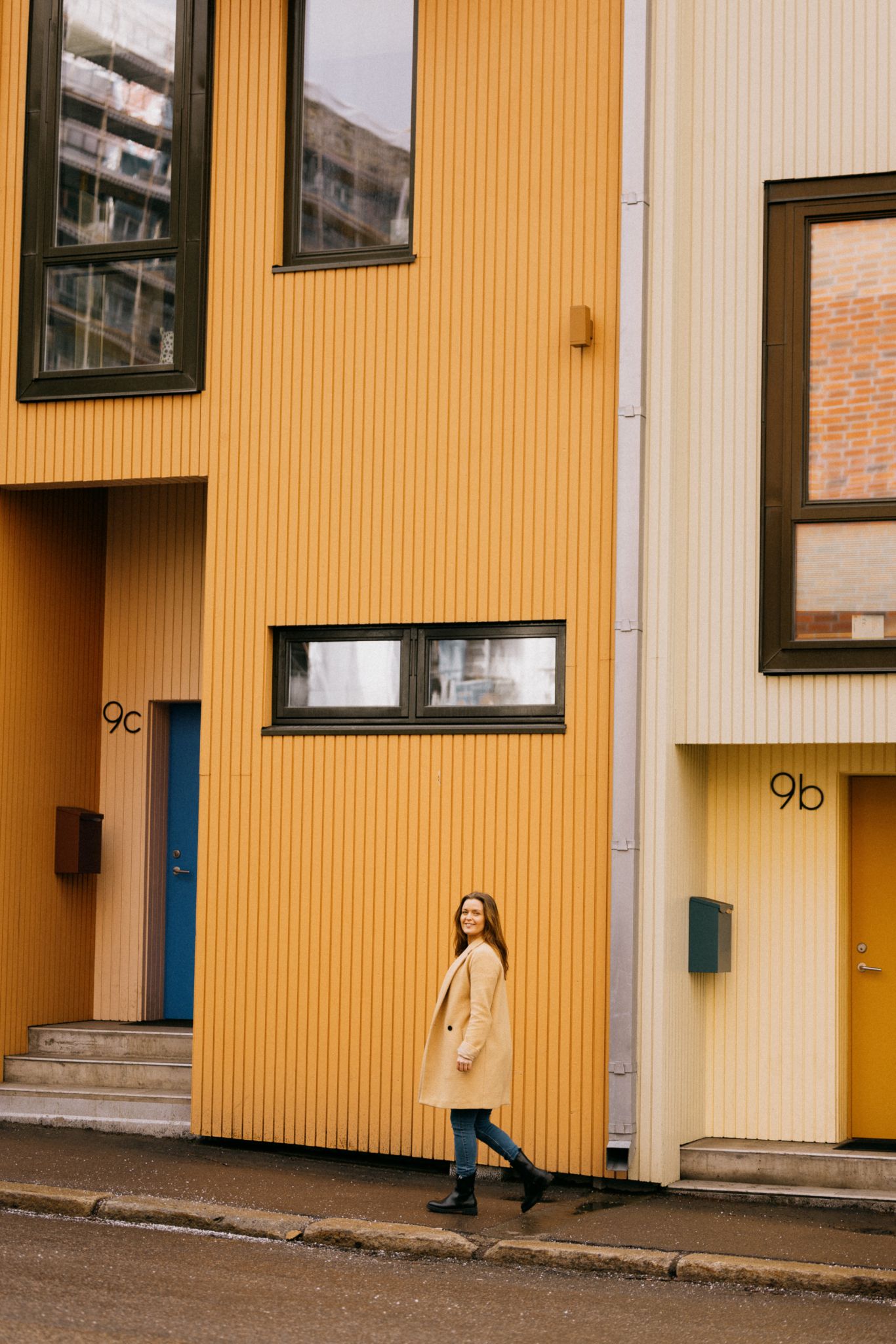 Portrett av Maria Tøsse gående foran fasader på Grünerløkka i Oslo.