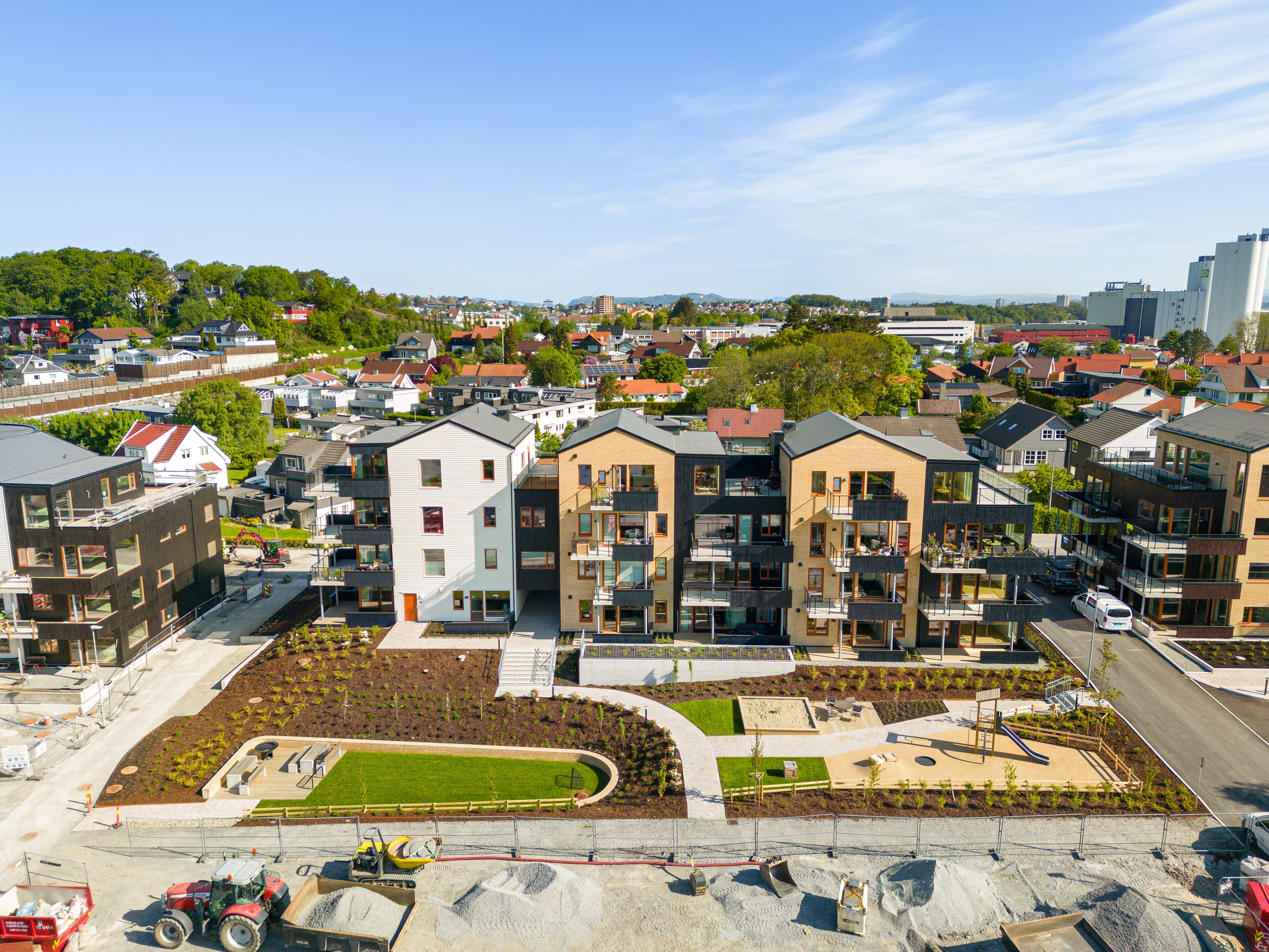 Foto av fasaden til byggene i boligprosjektet Mariebo med grønt uteområde.