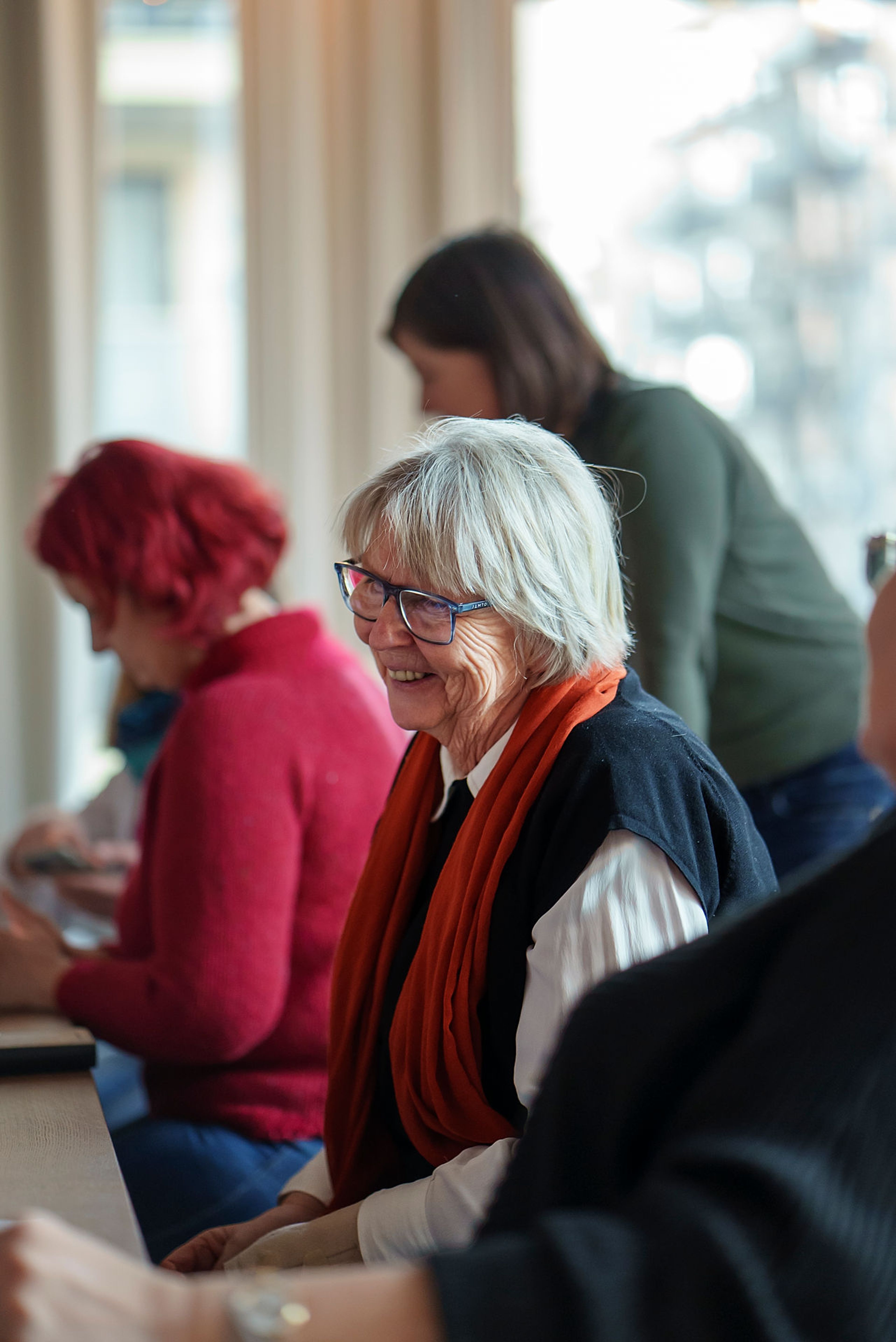 Bilde av Ulven-beboer Marit Holen på seniortreff, med to personer i bakgrunnen.