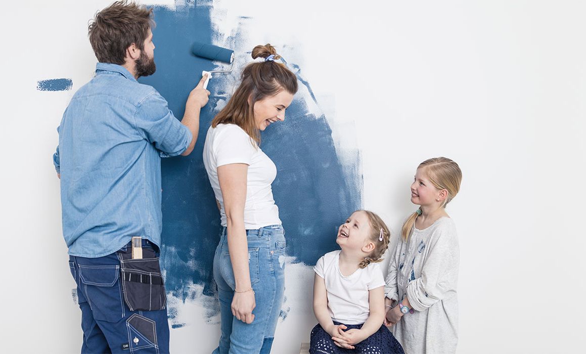 Familie som maler veggen blå.