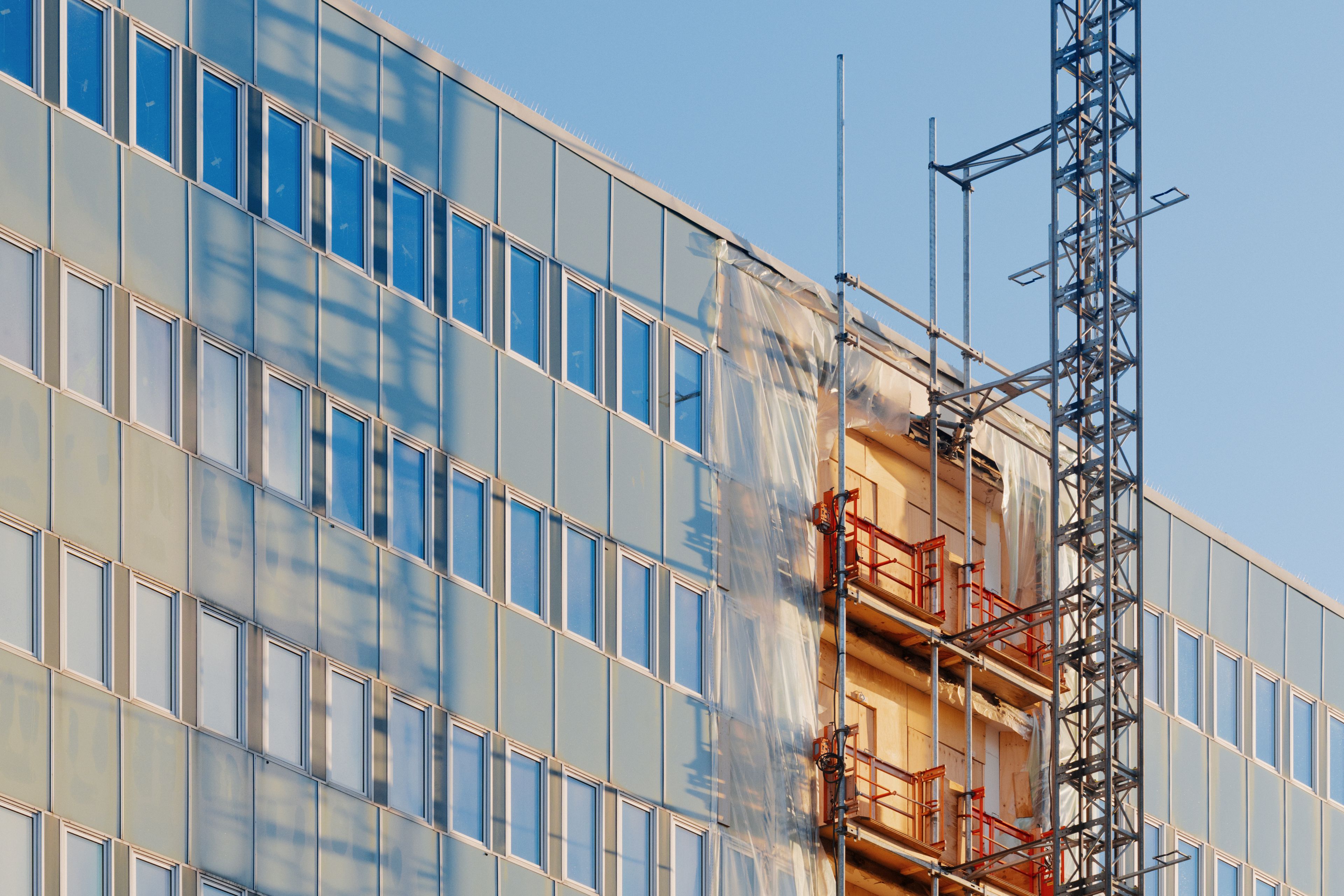 Foto av en fasade som pusses opp med nye balkonger.