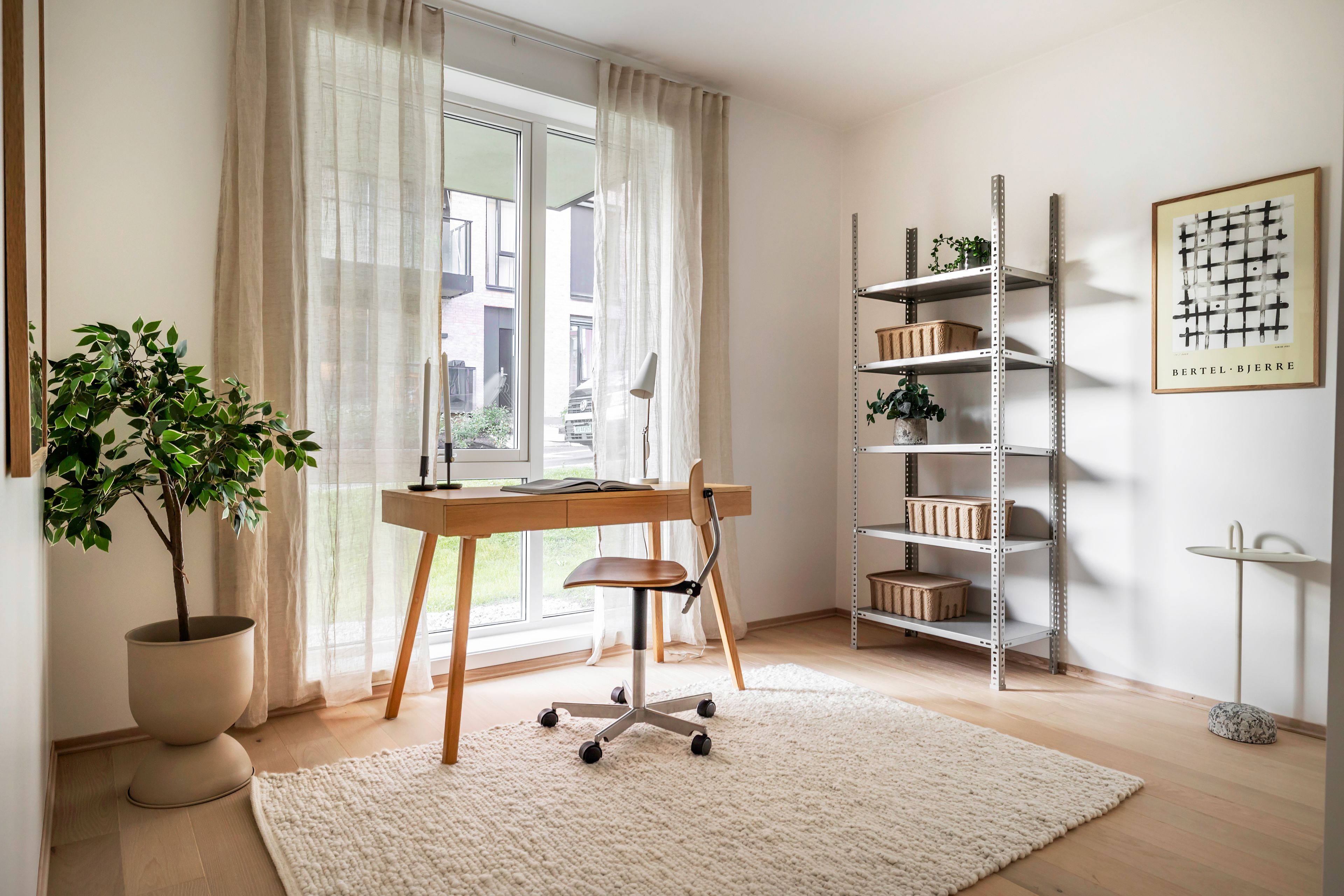 Soverom innredet med kontorplass foran store vinduer som går ned til gulvet i Løren botaniske.