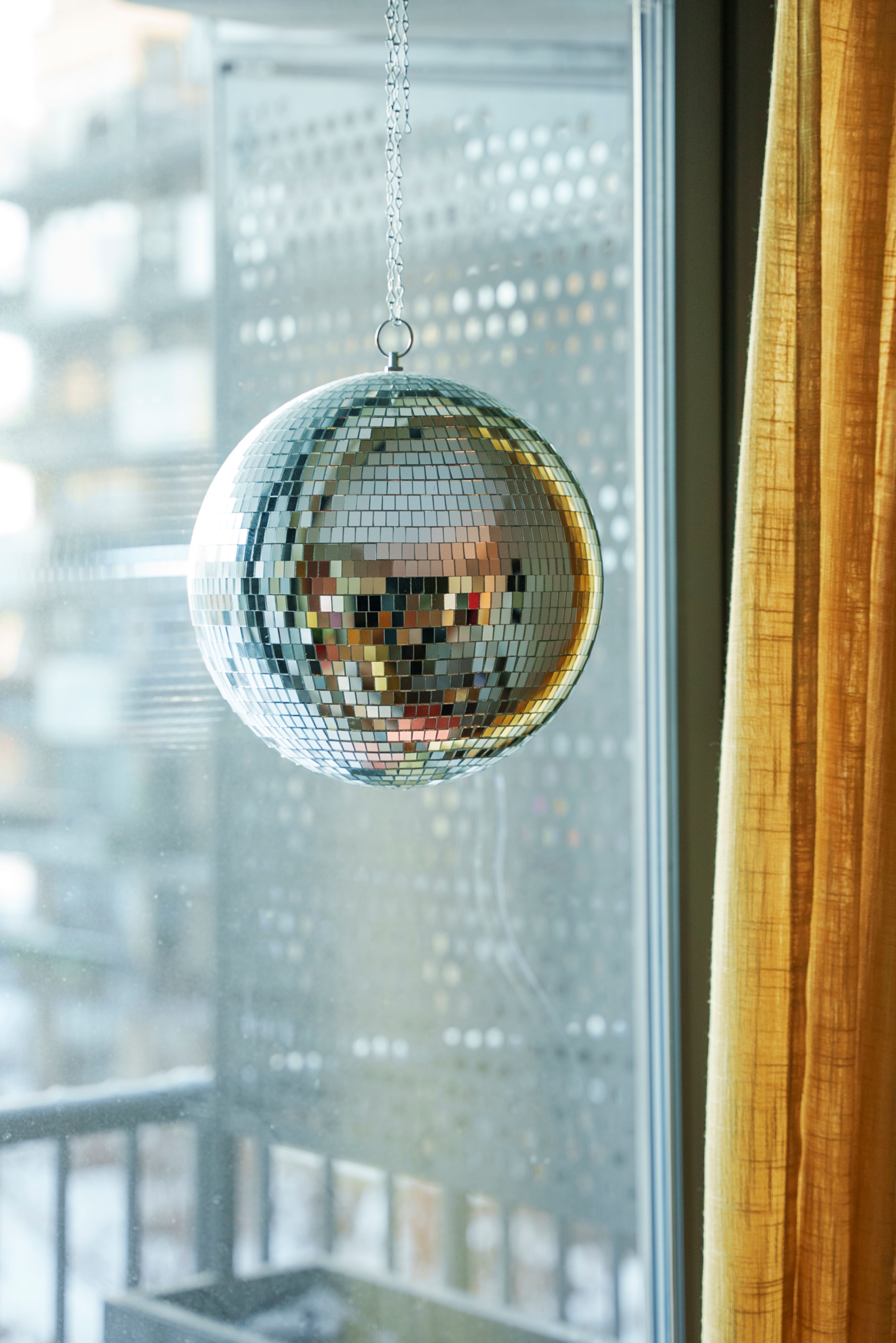 Sølvgrå discokule hengende i et vindu