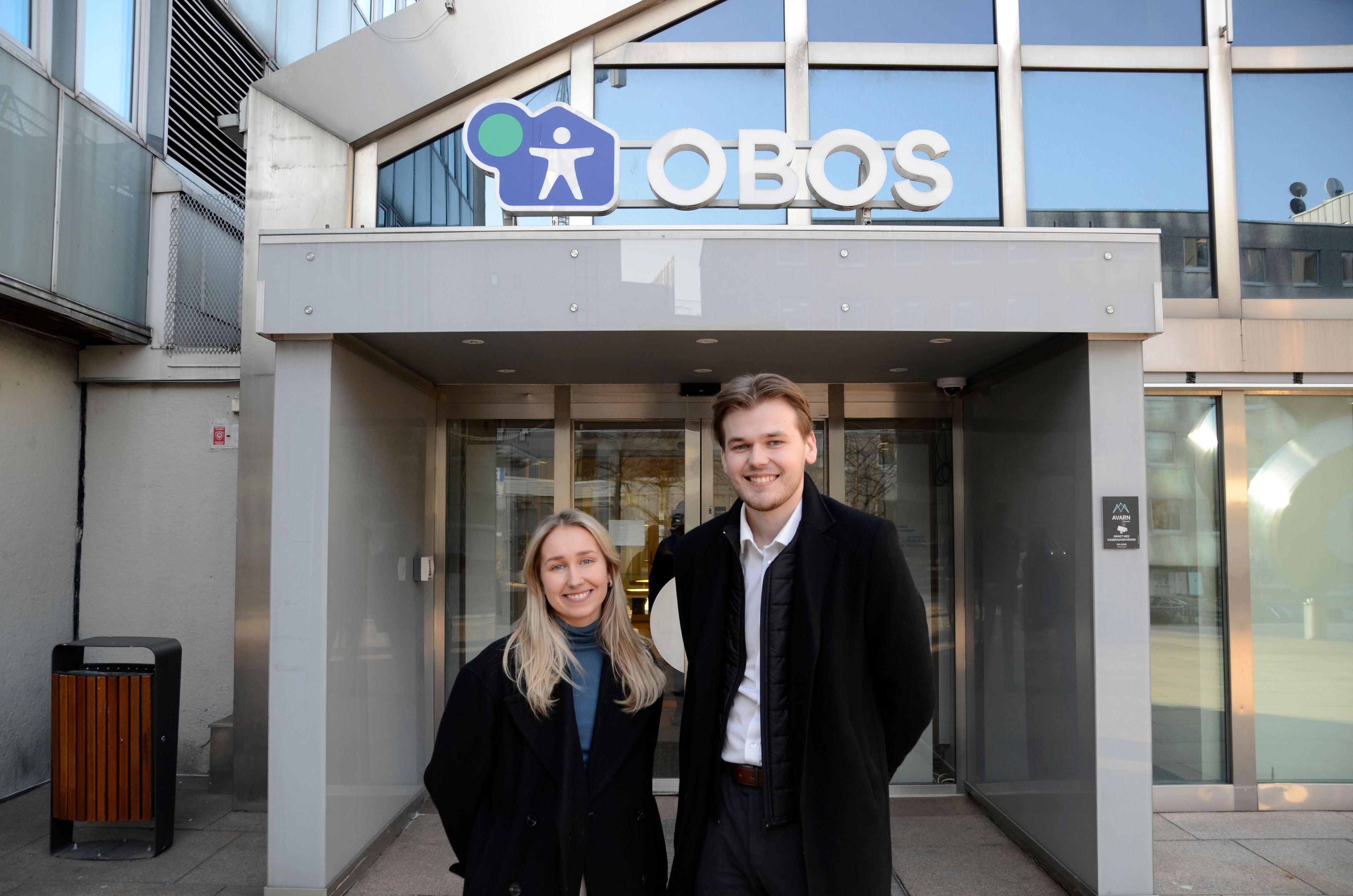 OBOS Eiensdomsmeglere Sigrid og Johan foran OBOS hovedinngang.