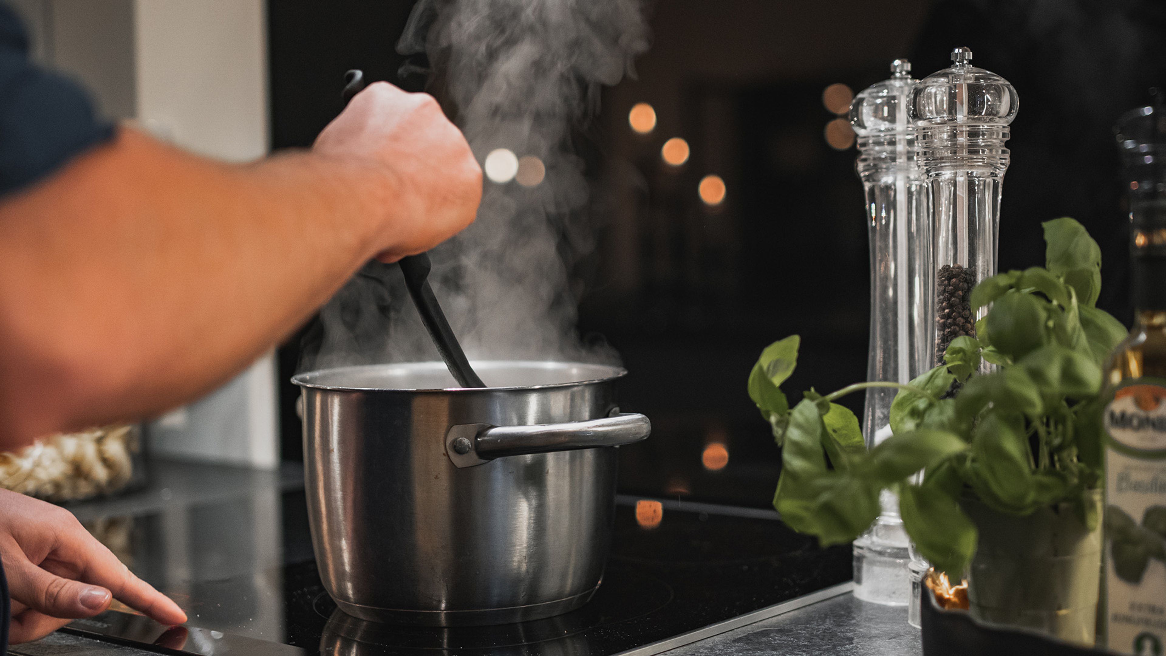 man som lagar mat i köket och rör i en gryta