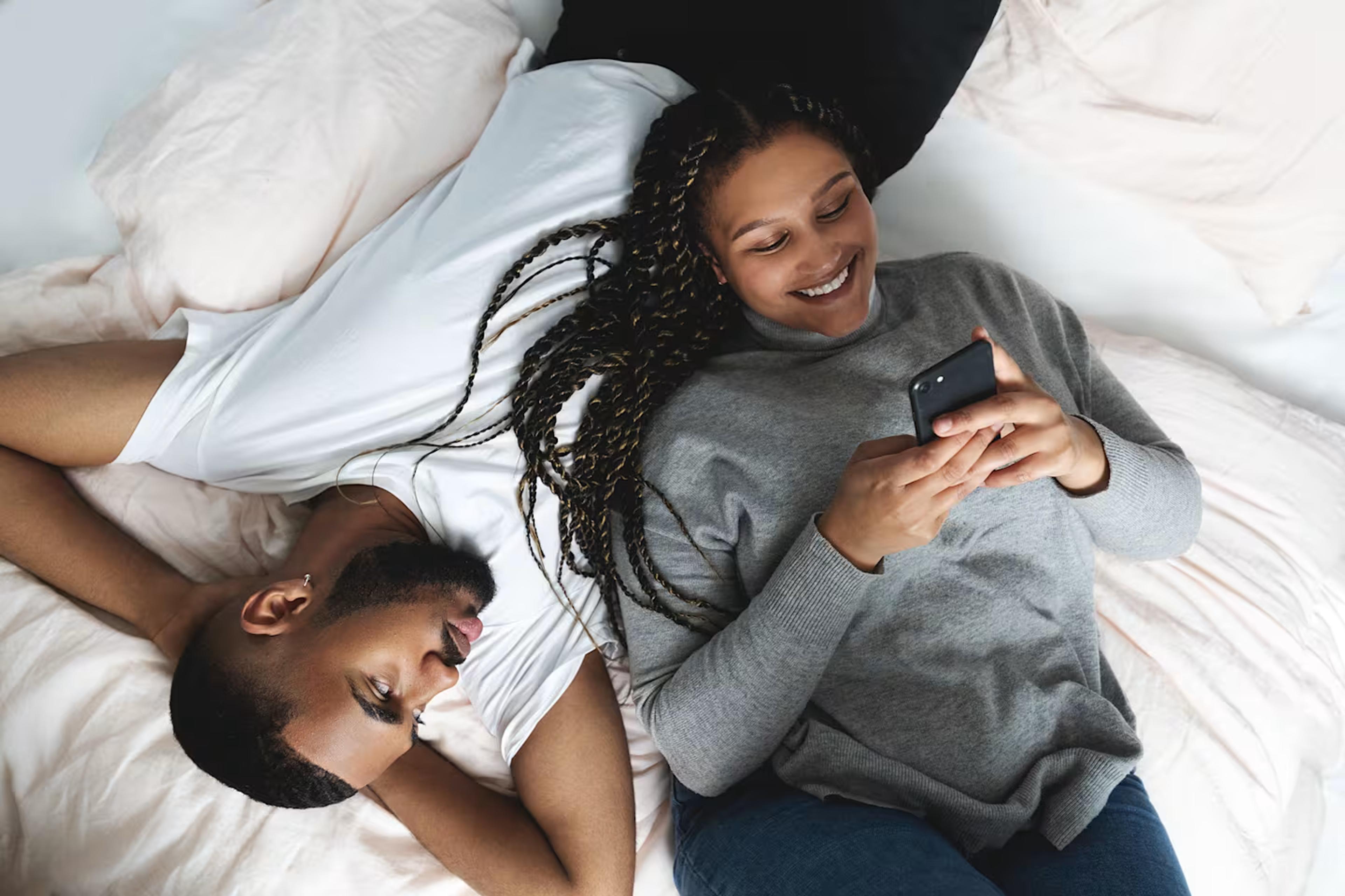 mann og kvinne som ligger på en seng