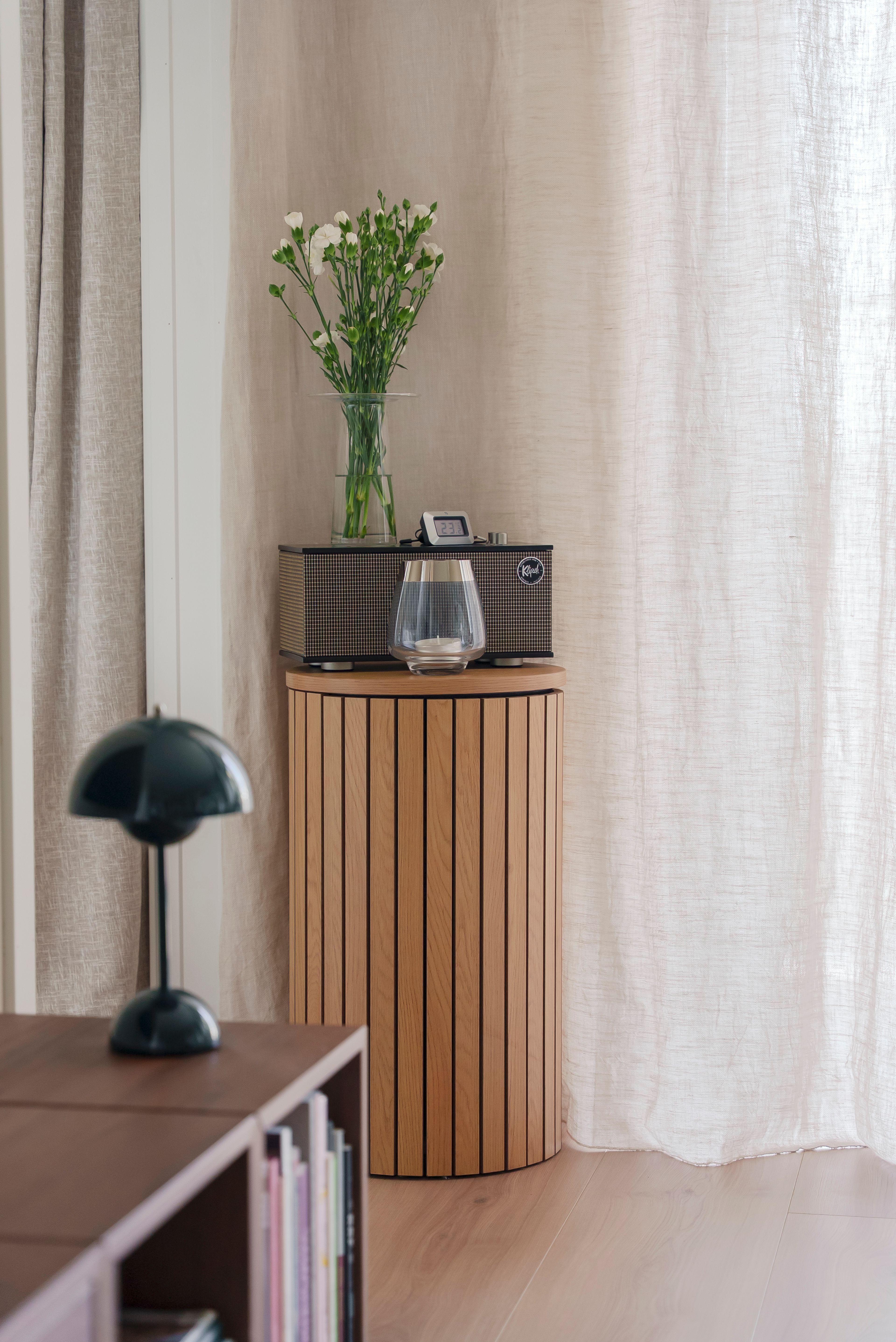 Detaljebilde fra stuen, med en høyttaler og en vase.