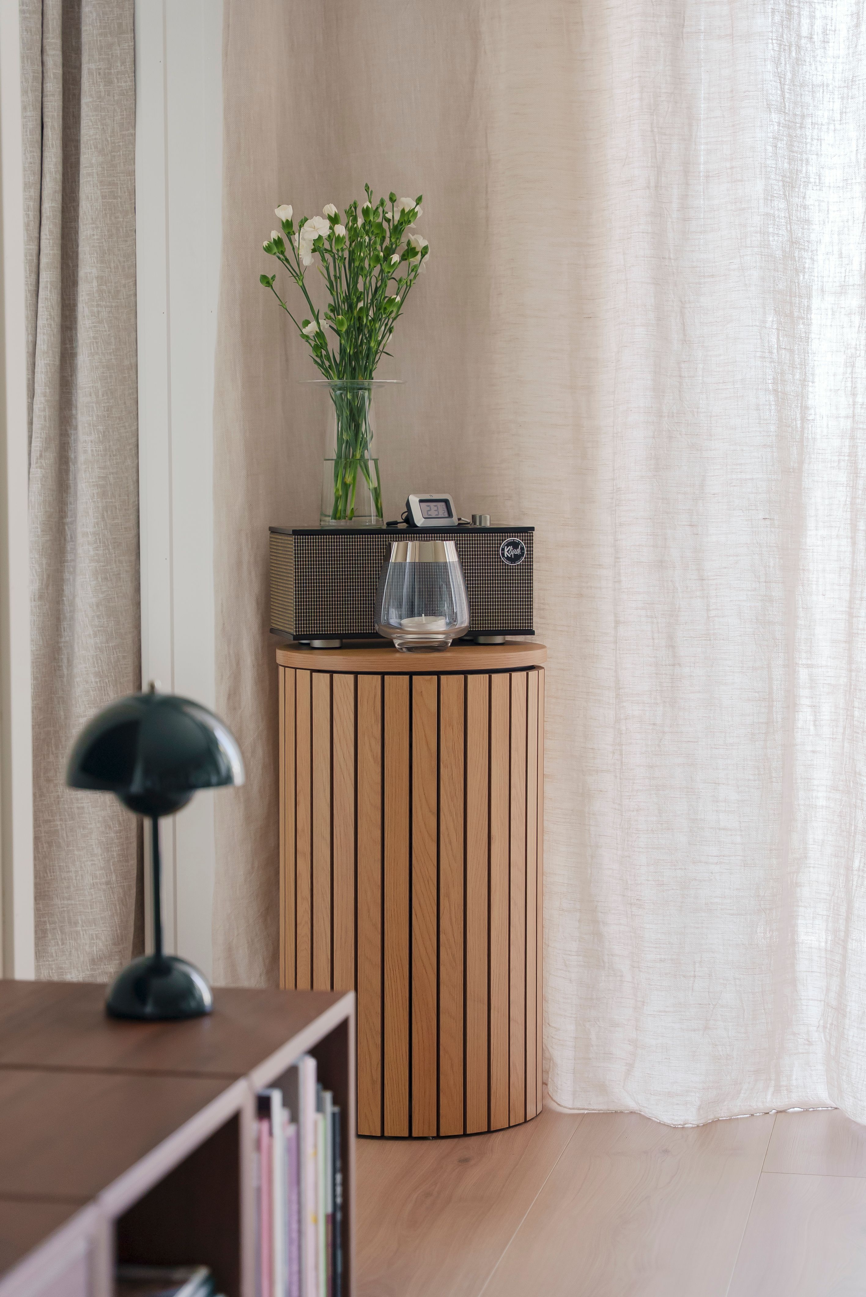 Detaljebilde fra stuen, med en høyttaler og en vase.