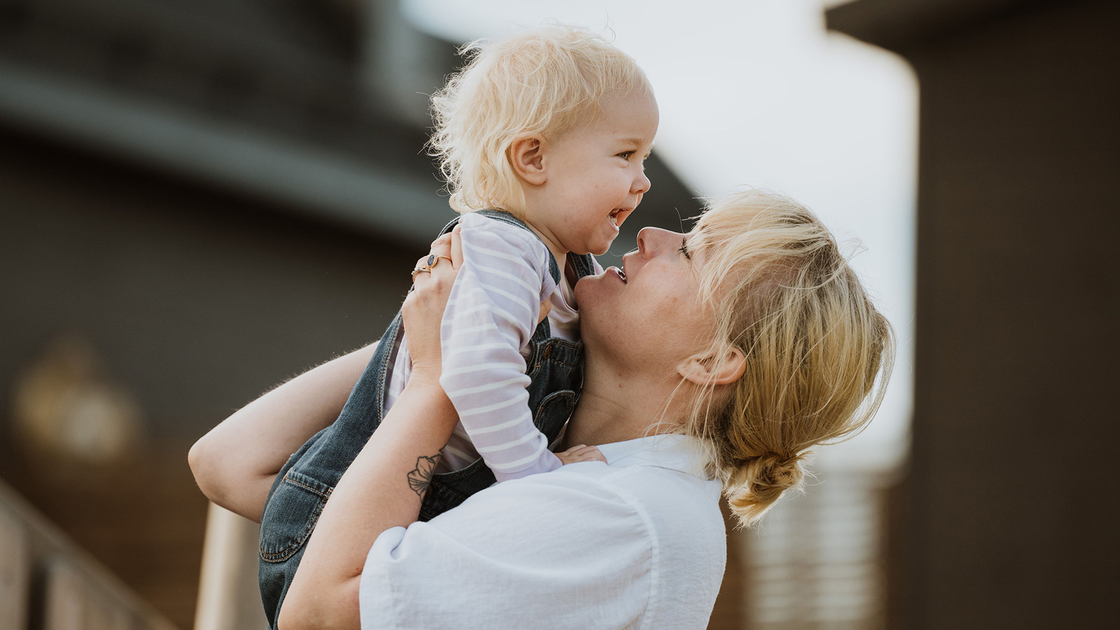 En mor holder sin datter som smiler.