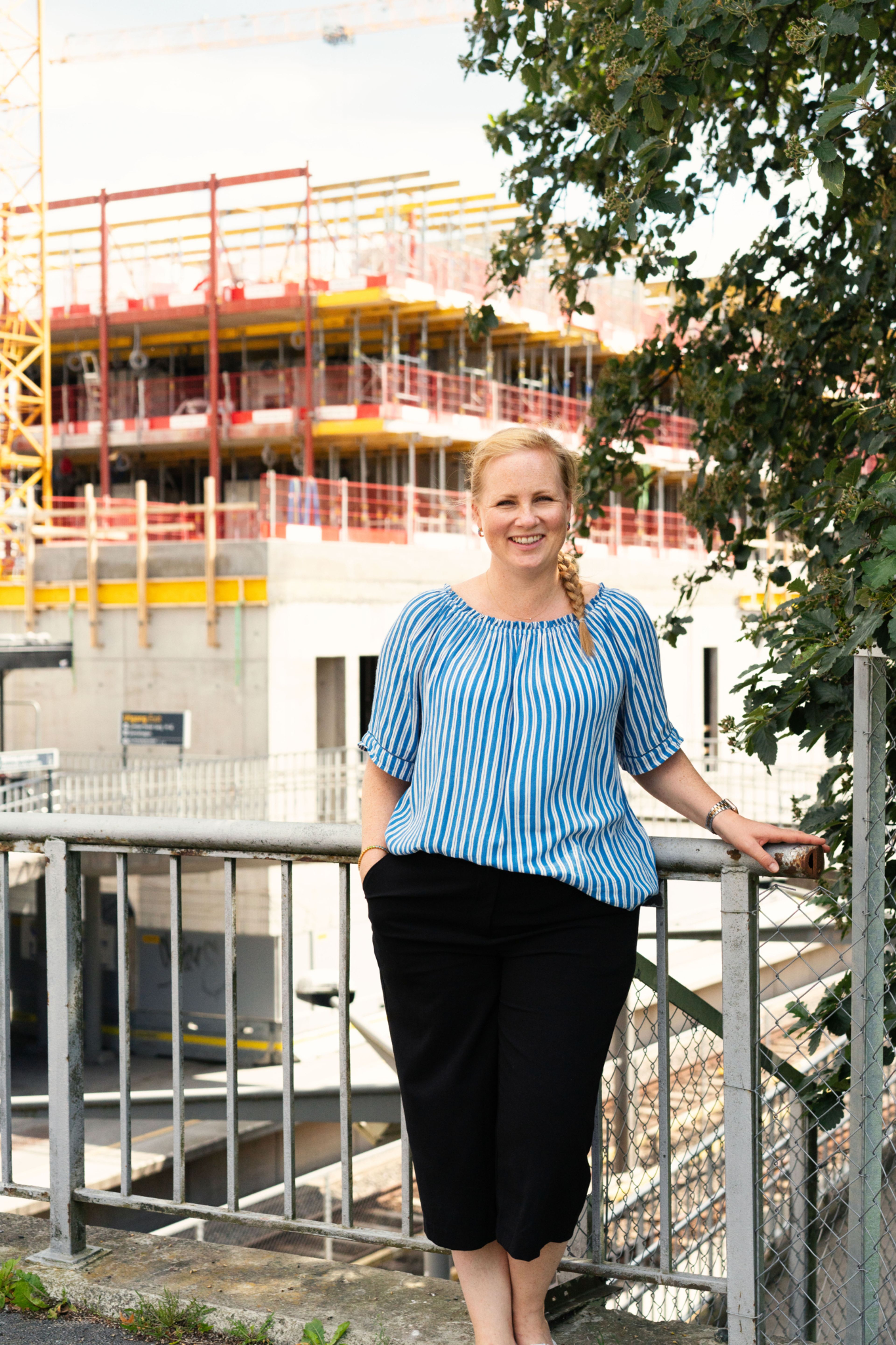 Prosjektleder Trine Hauglund Overgård står foran et leilighetsbygg