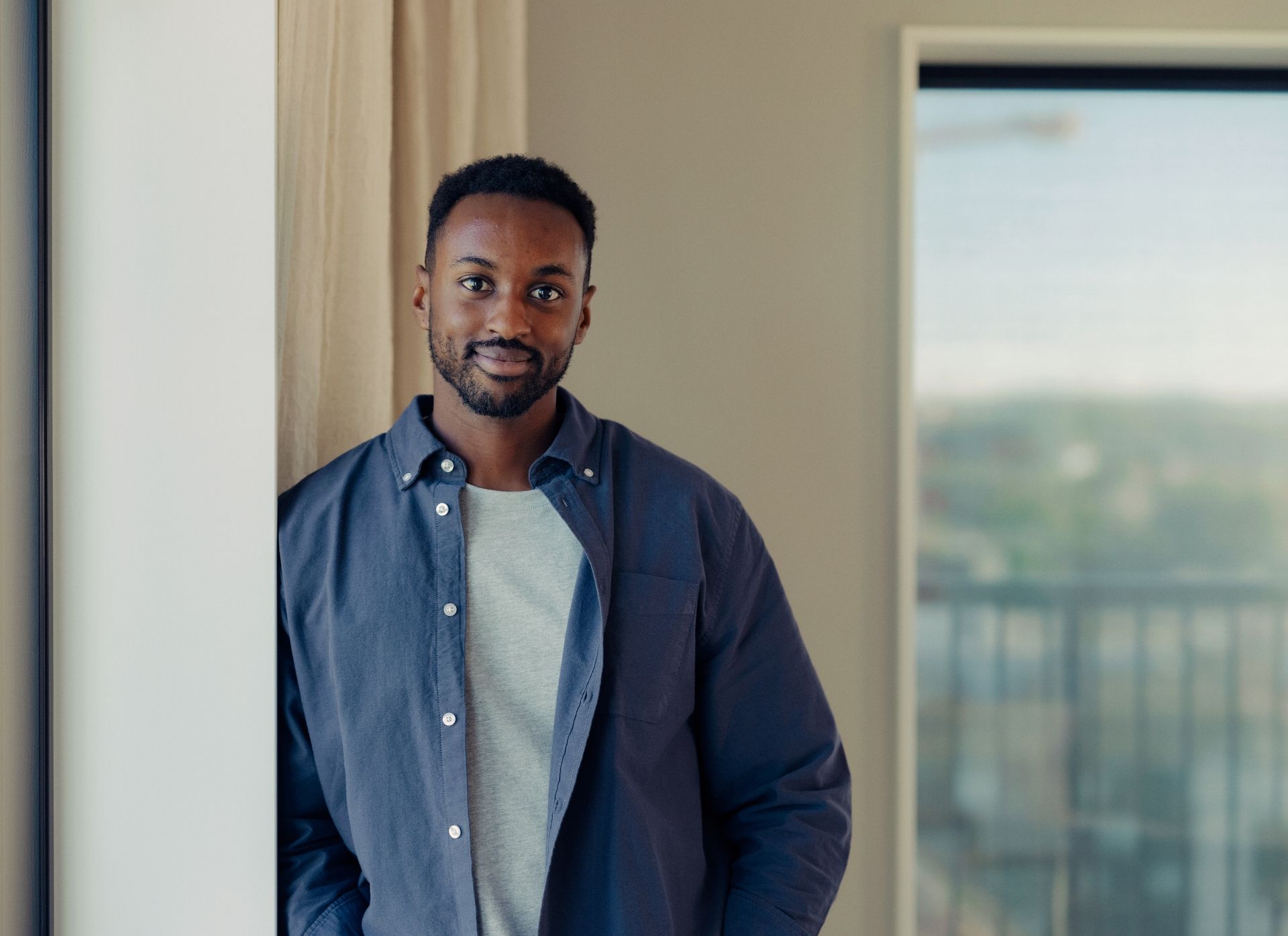 En smilende mann ser rett i kamera. 