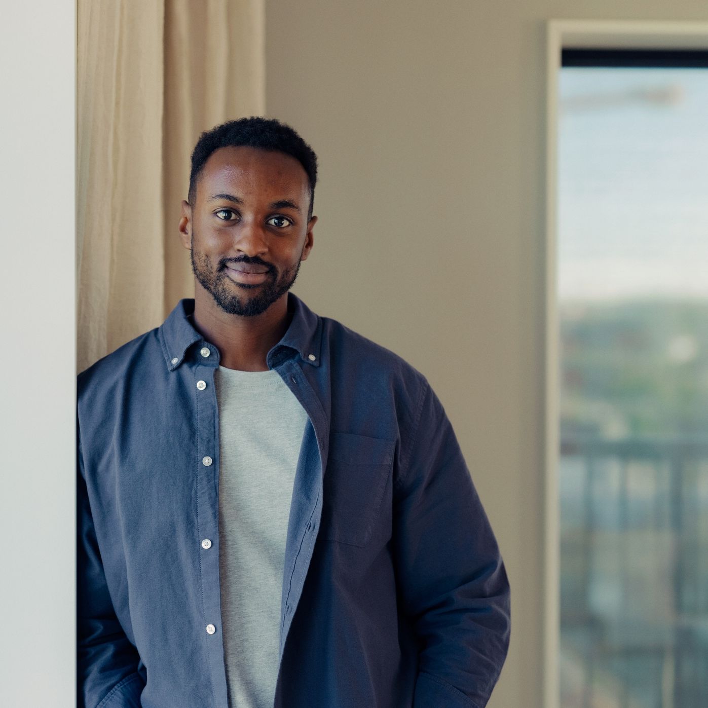 En smilende mann ser rett i kamera.