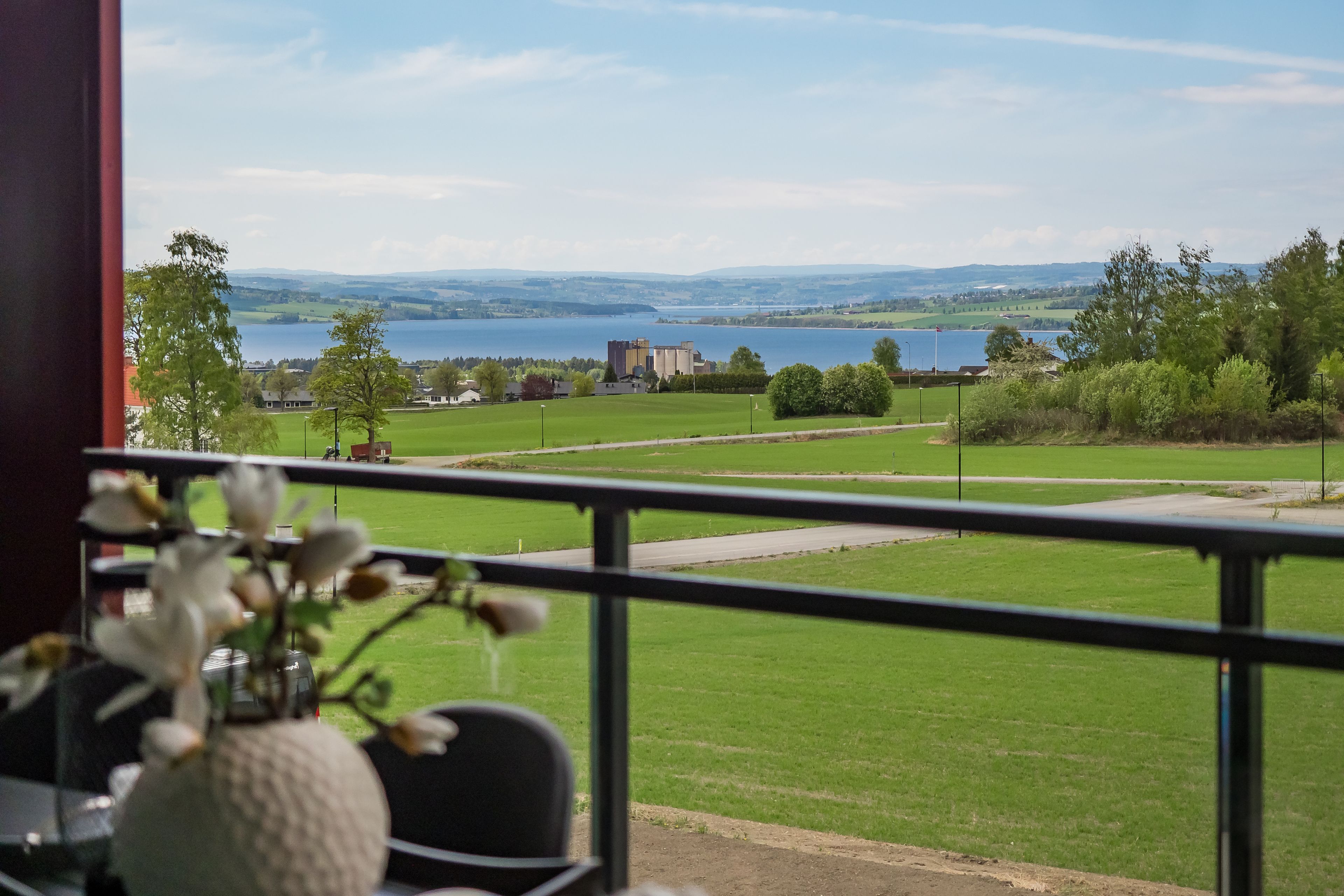 Utsikt mot grøntområder og Mjøsa fra balkong på Sollitunet