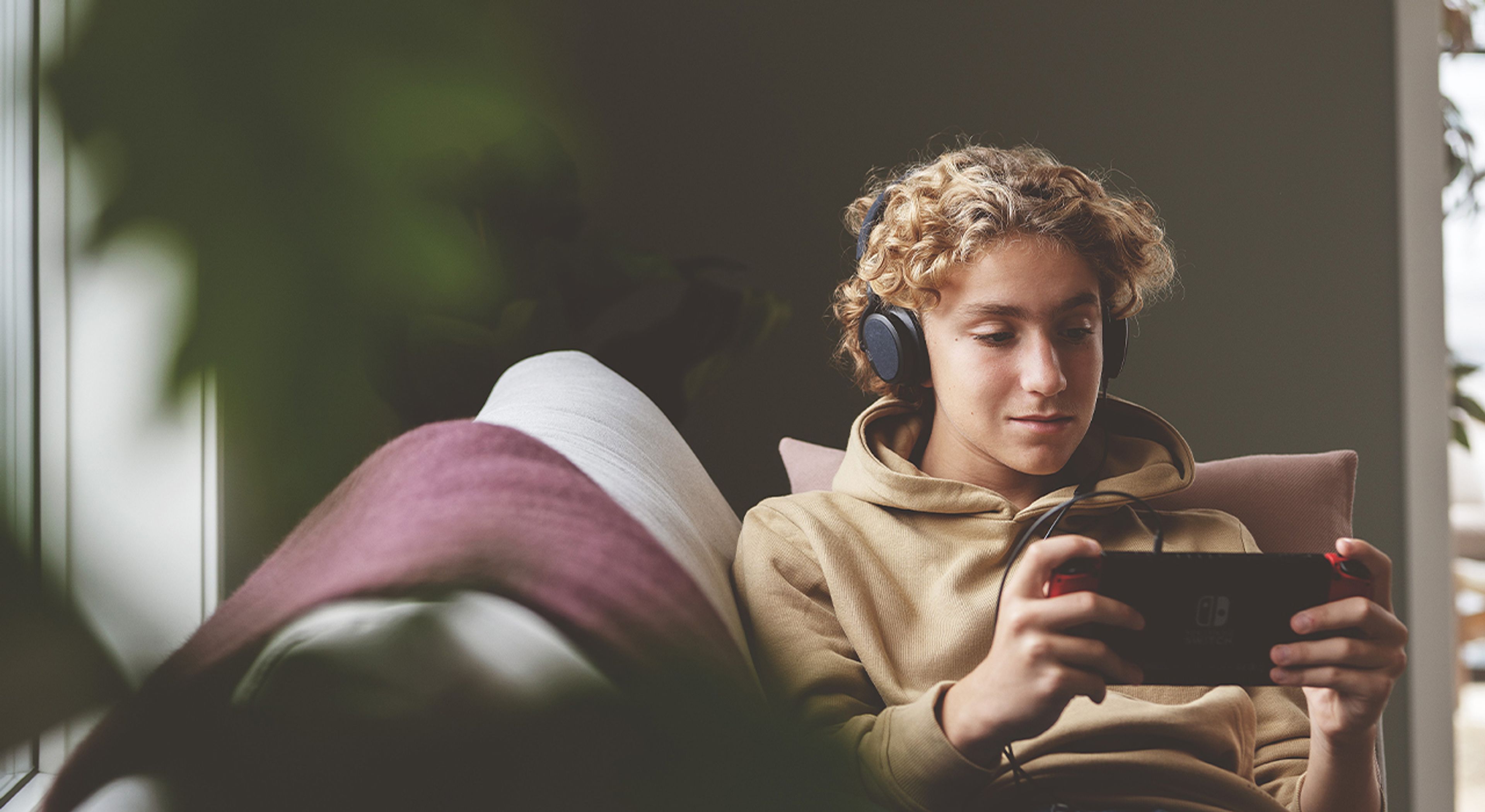Gutt som spiller på sin Nintendo Switch