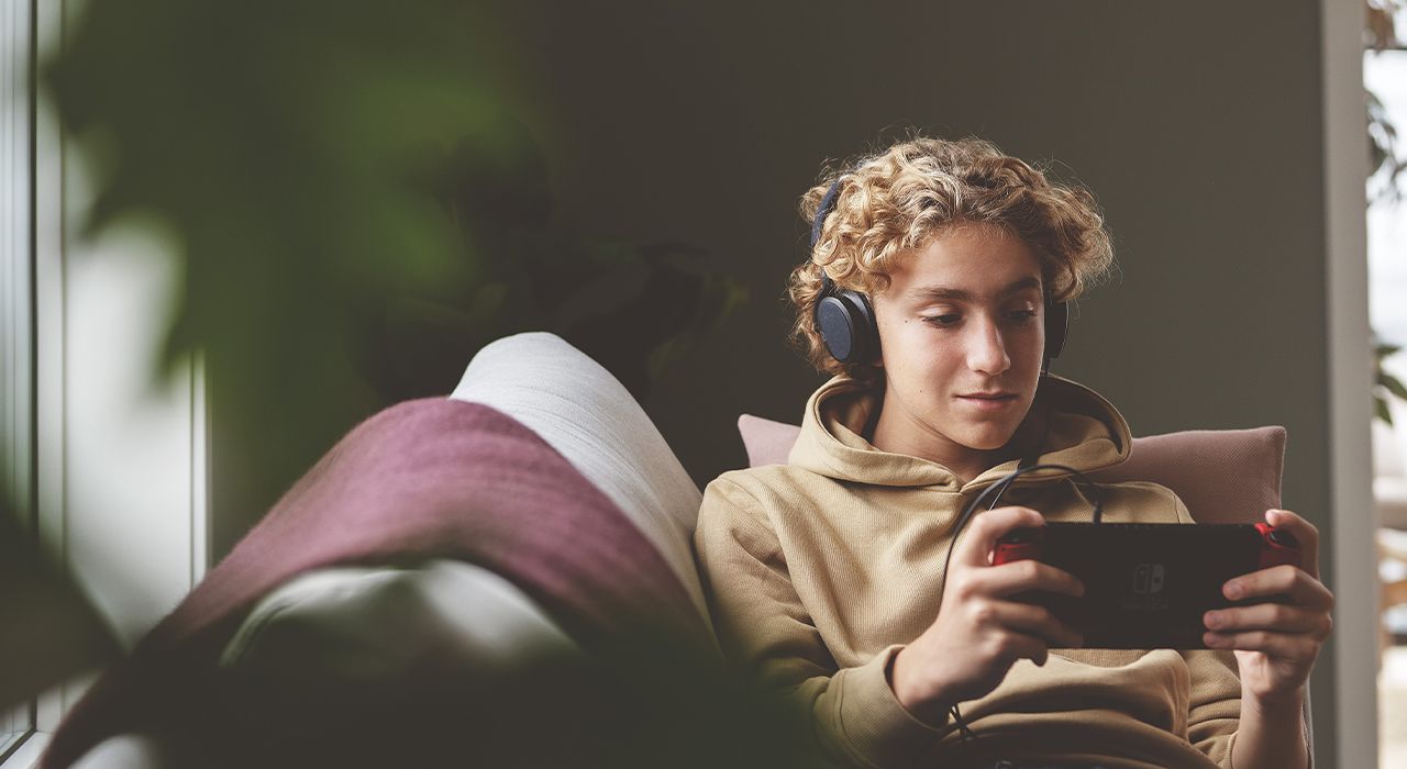 Gutt som spiller på sin Nintendo Switch