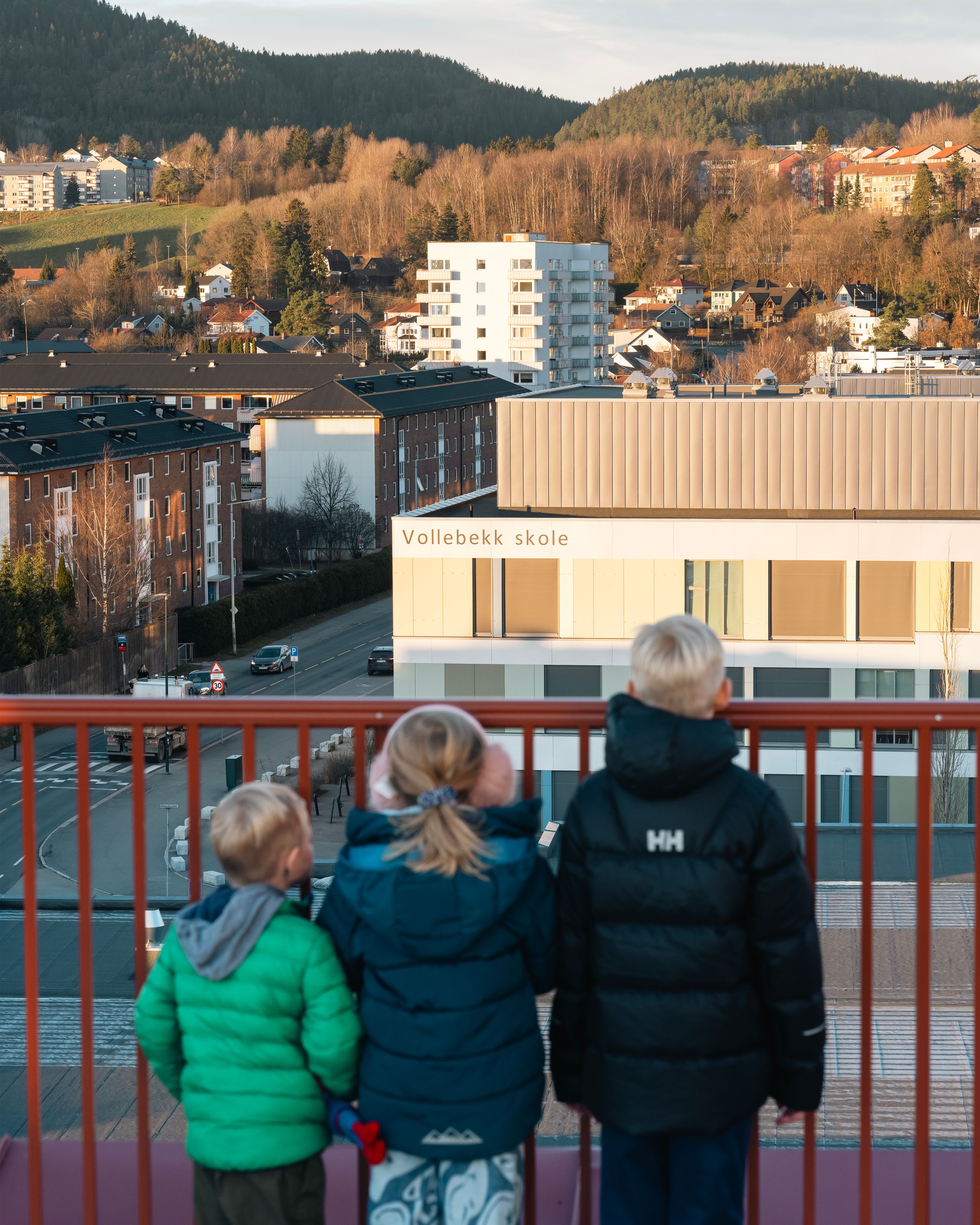 Foto av barna til Kristin som ser ned på Vollebekk skole, fra takterrassen