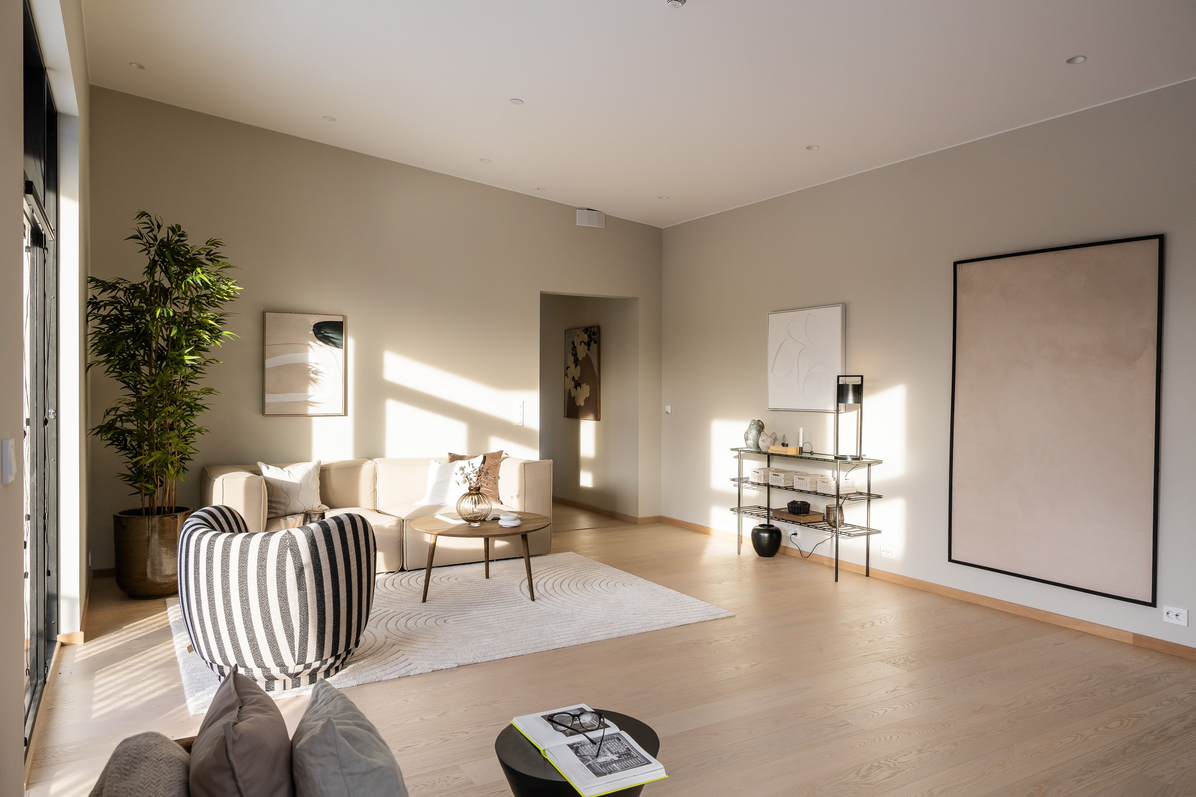 Foto av stue med sofa, lenestol og hylle.