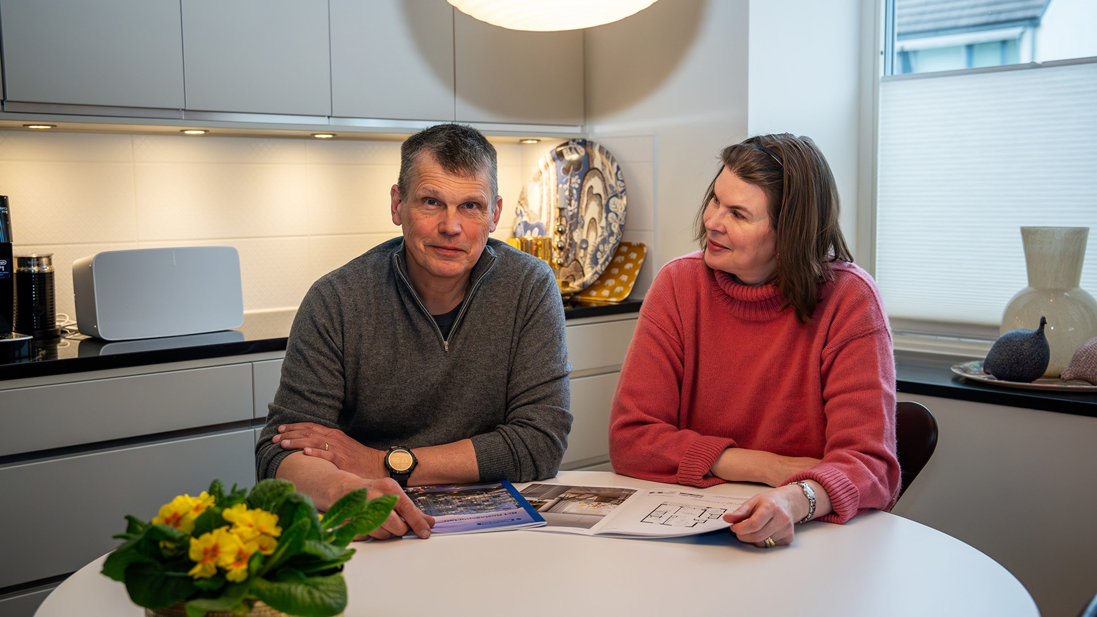 man och kvinna sitter tillsammans vid köksbordet