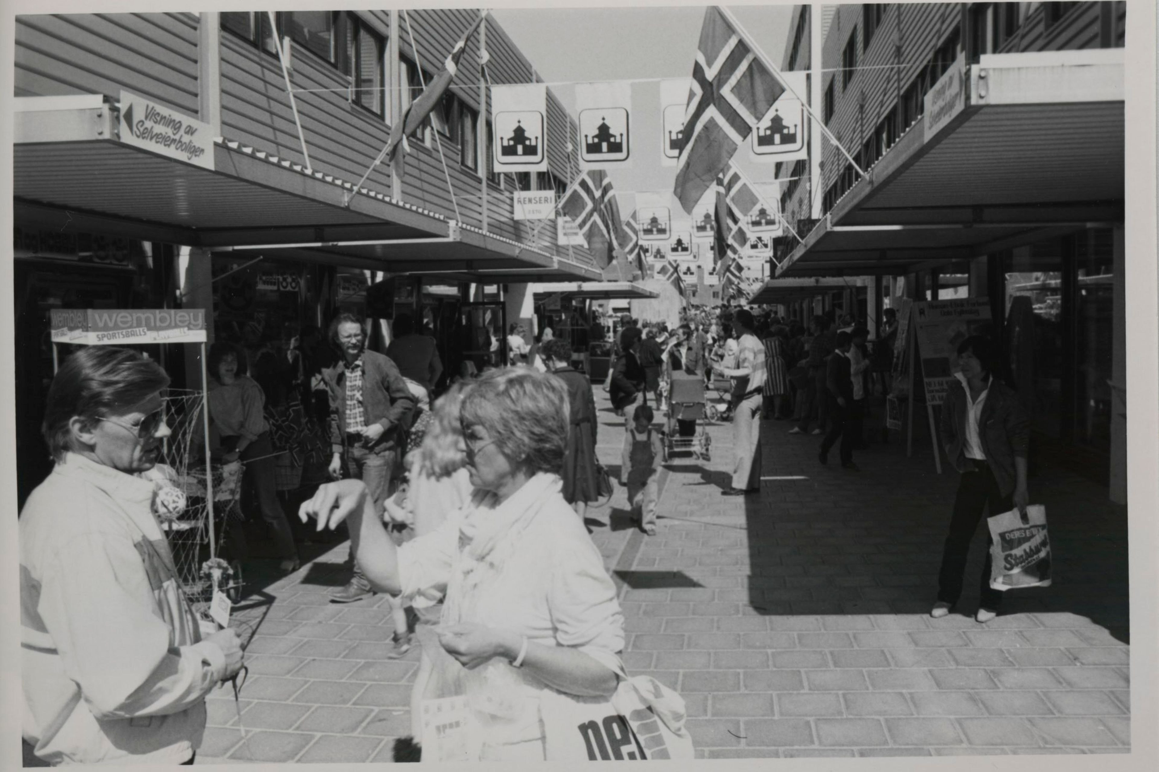 En mann og en dame samtaler mellom butikkene på Holmlia Senter.