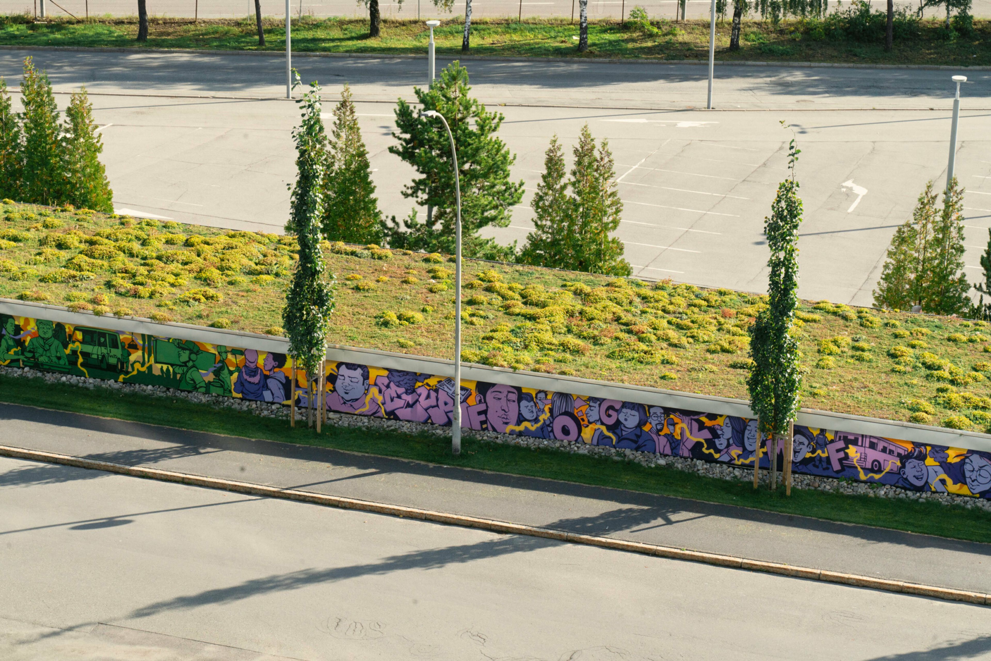 Foto av en lang garasjevegg med grafittikunst.