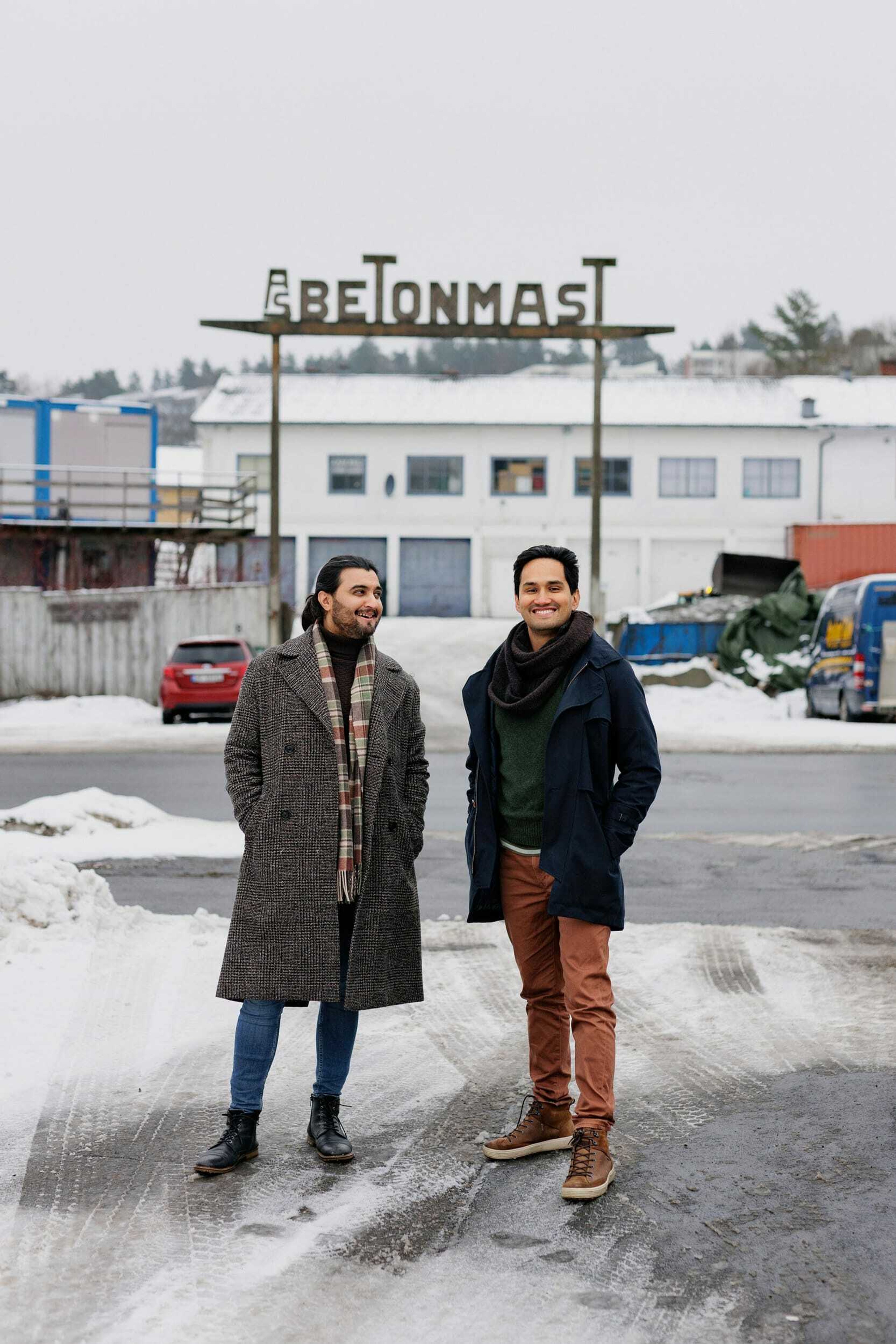 Foto av Mario Vahos og Osman Ilyas foran et skilt til Betonmast.