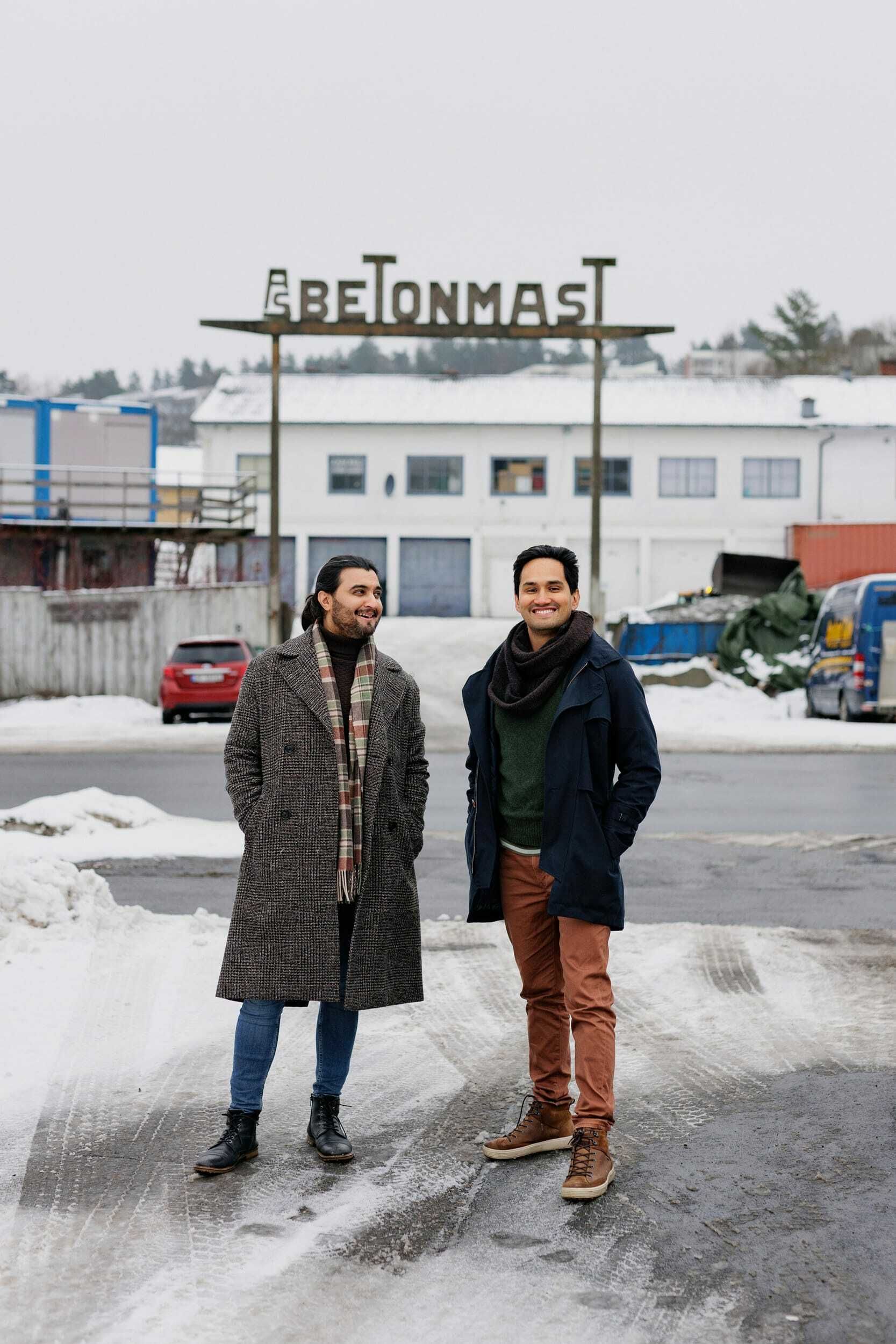 Foto av Mario Vahos og Osman Ilyas foran et skilt til Betonmast.
