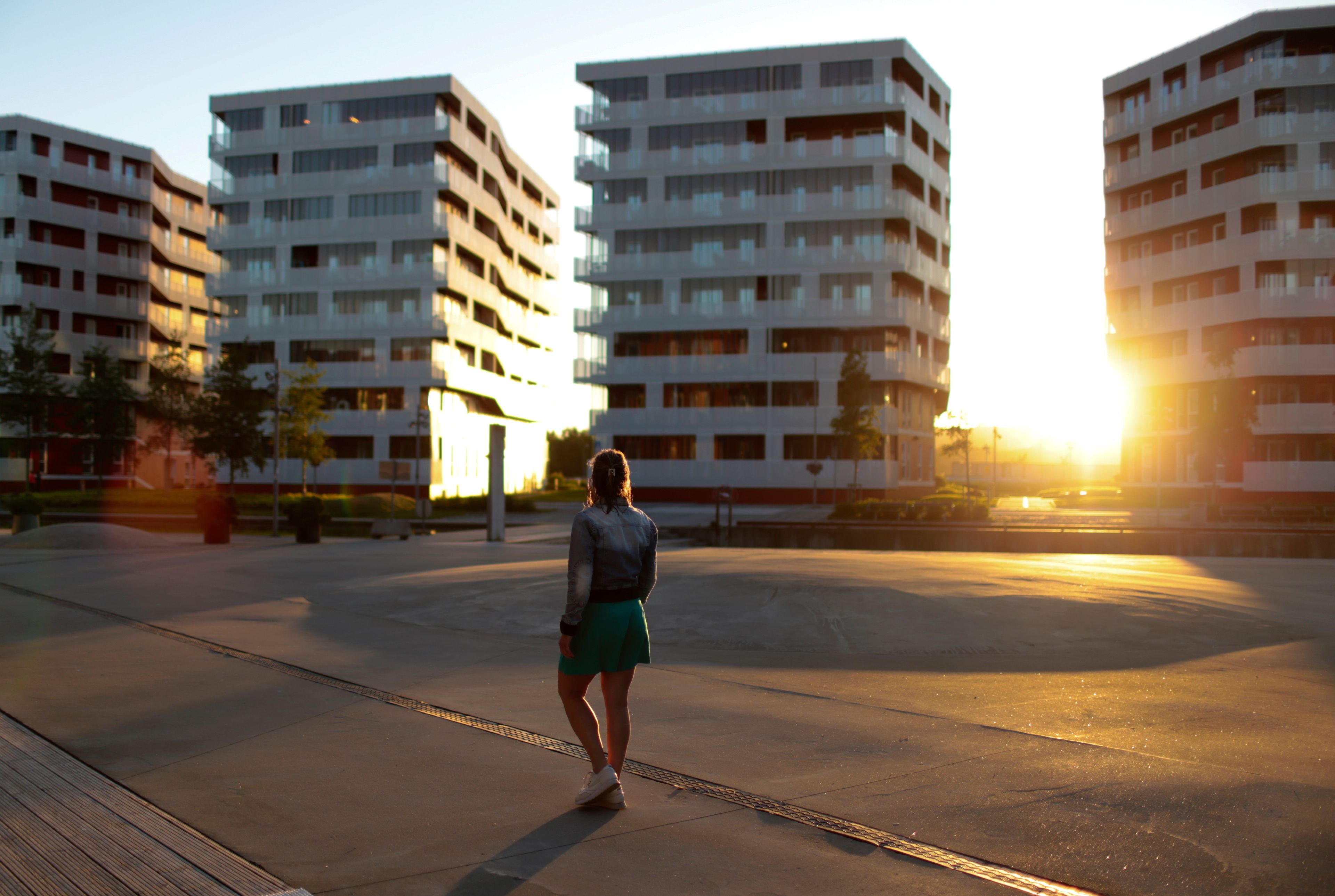 En kvinne som går på fortauet blant boligblokkene på Hinna Park.