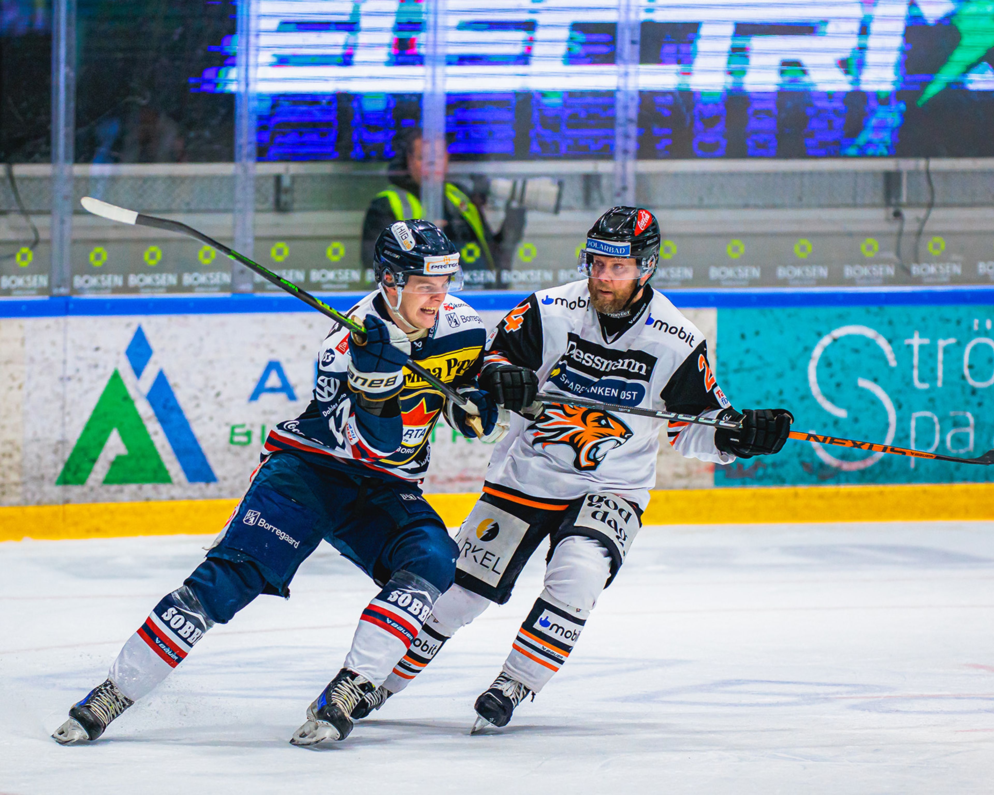 To ishockeyspillere kjemper om å få tak i hockeypucken.
