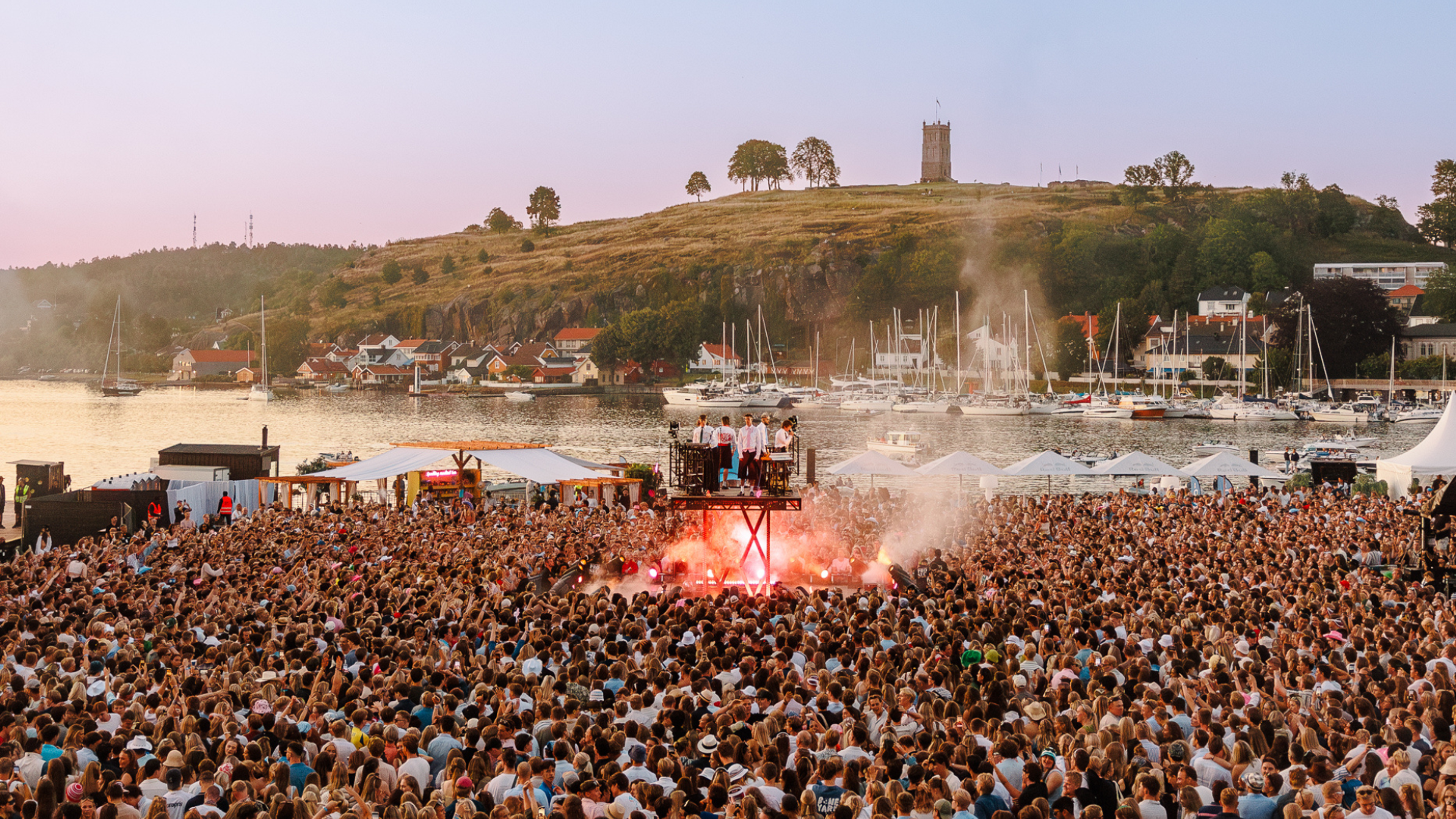 Festivalområdet på Slottsfjell med masse publikum rund en opphøyd scene og havnen i bakgrunnen.