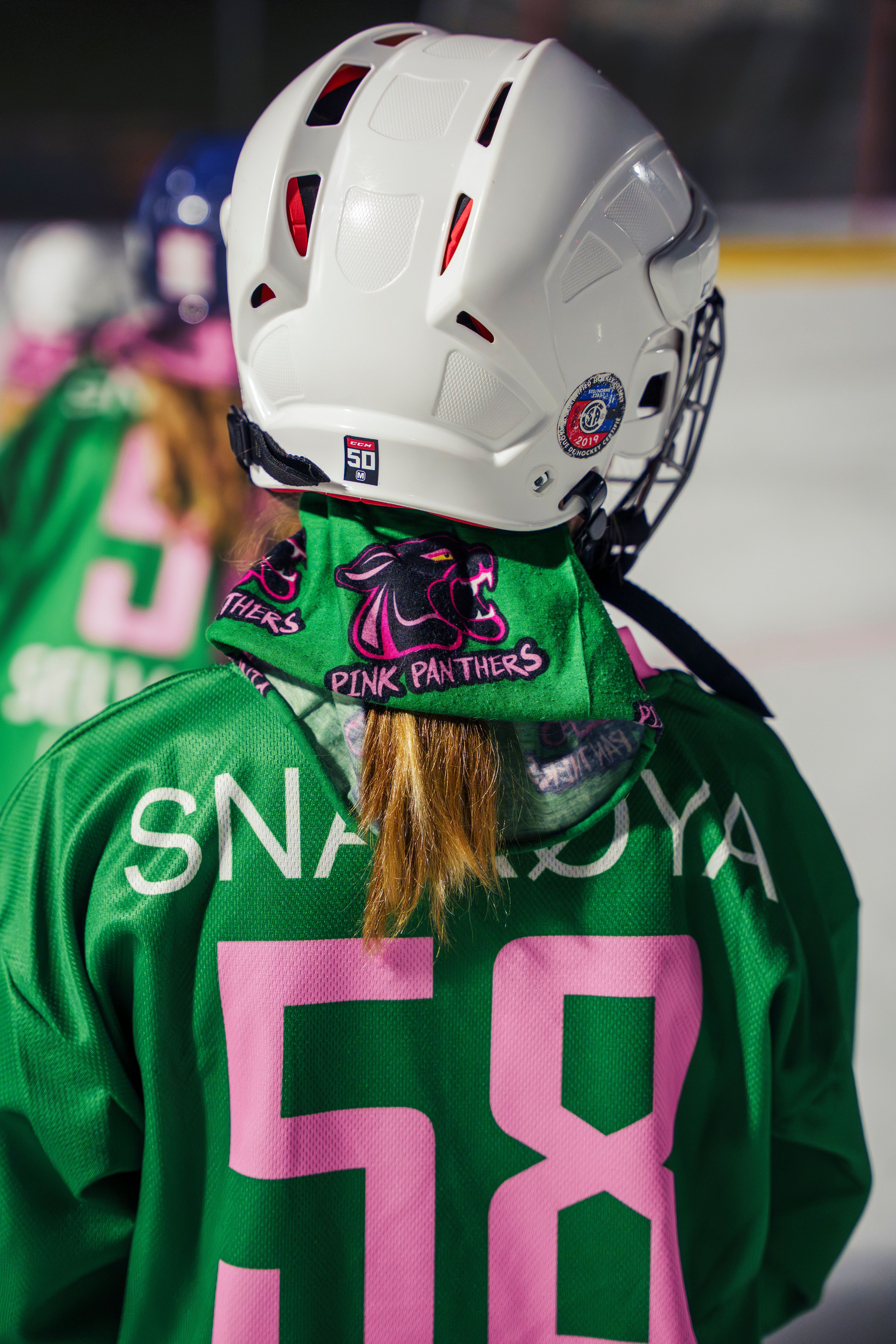 Nærbilde av ryggen på en av bandyjentene.