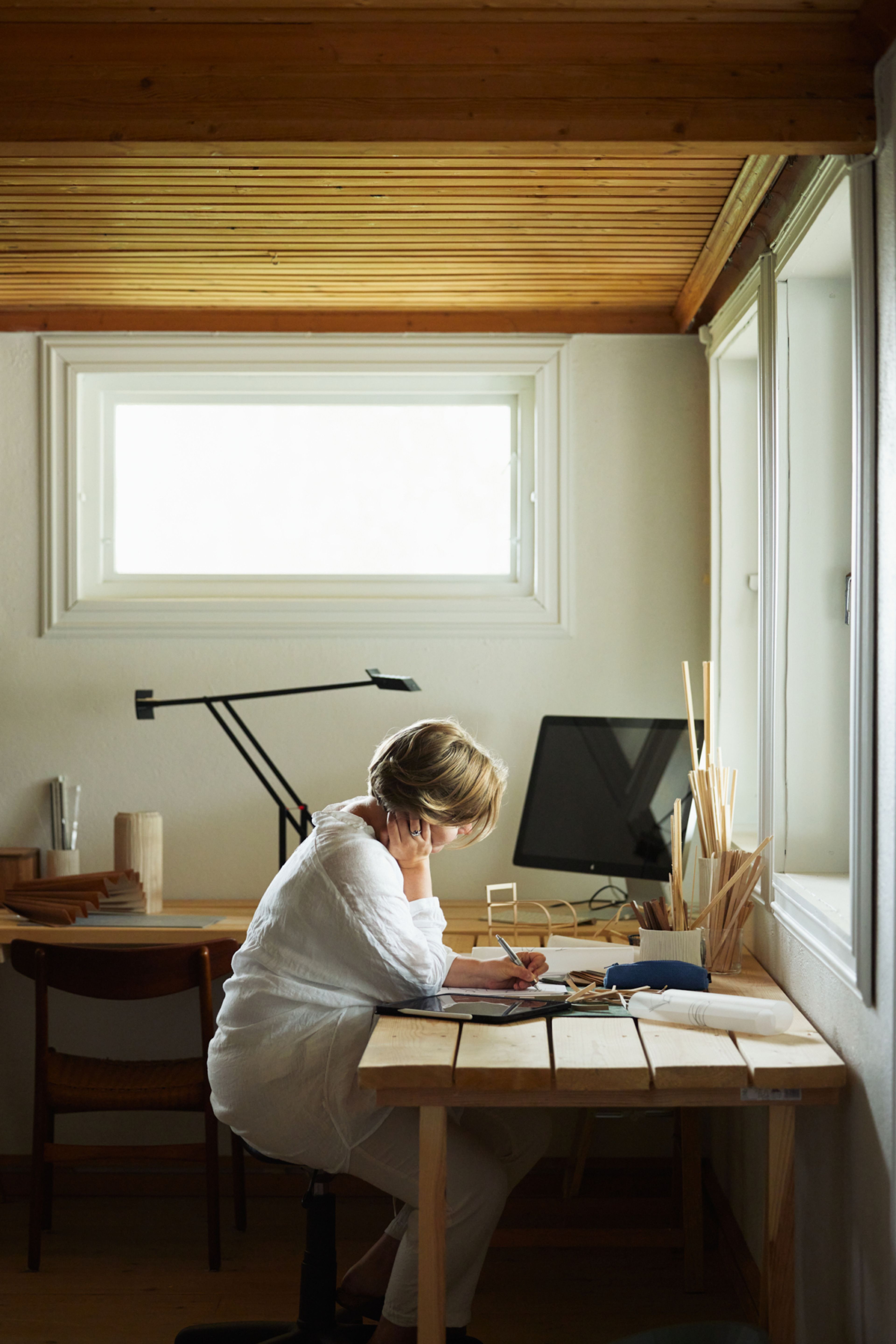 Vilde sitter ved pulten i studioet sitt.
