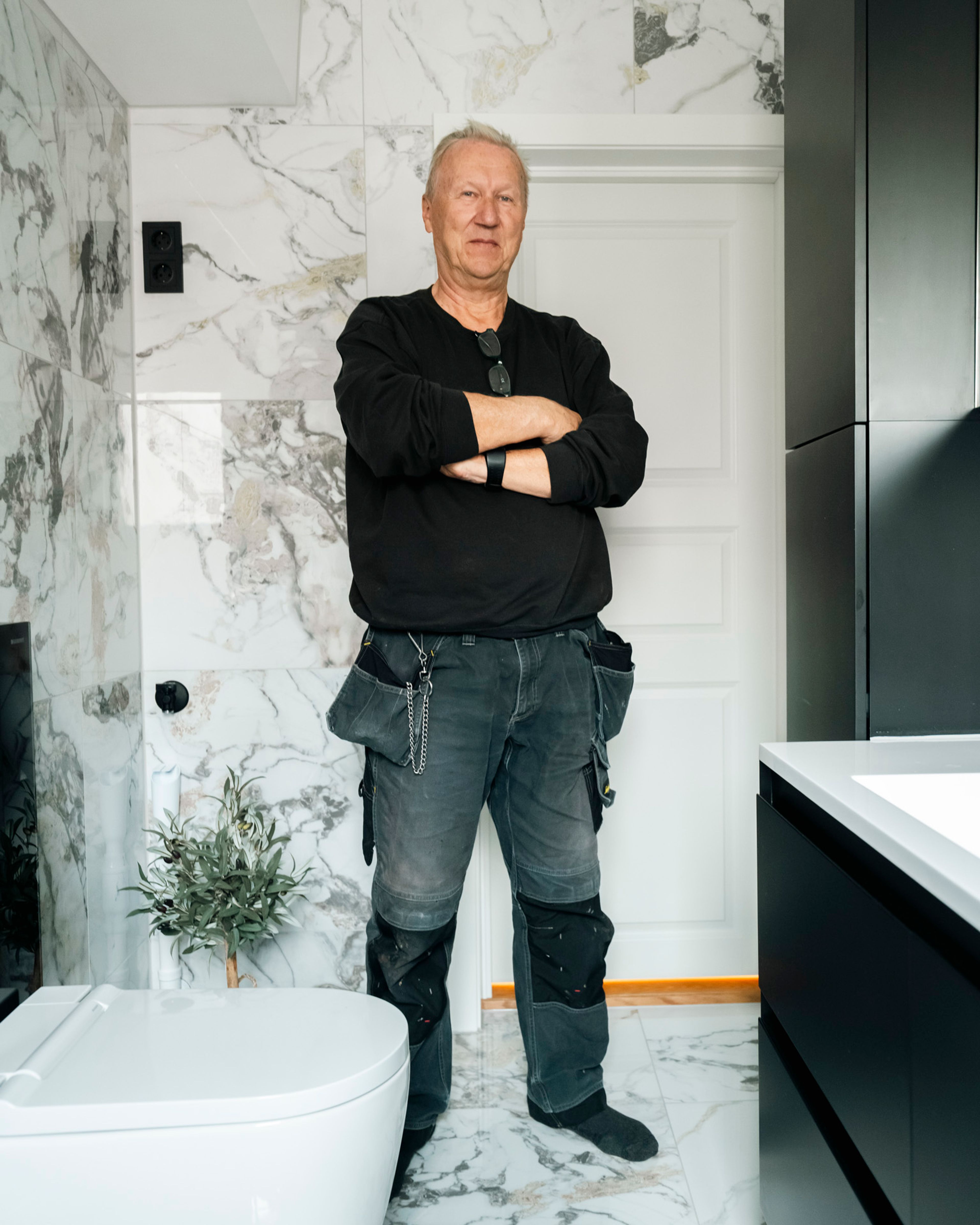 Vaktmester og beboer Tor Arne Adamsen på sitt nyoppussede bad med marmorliknende fliser.