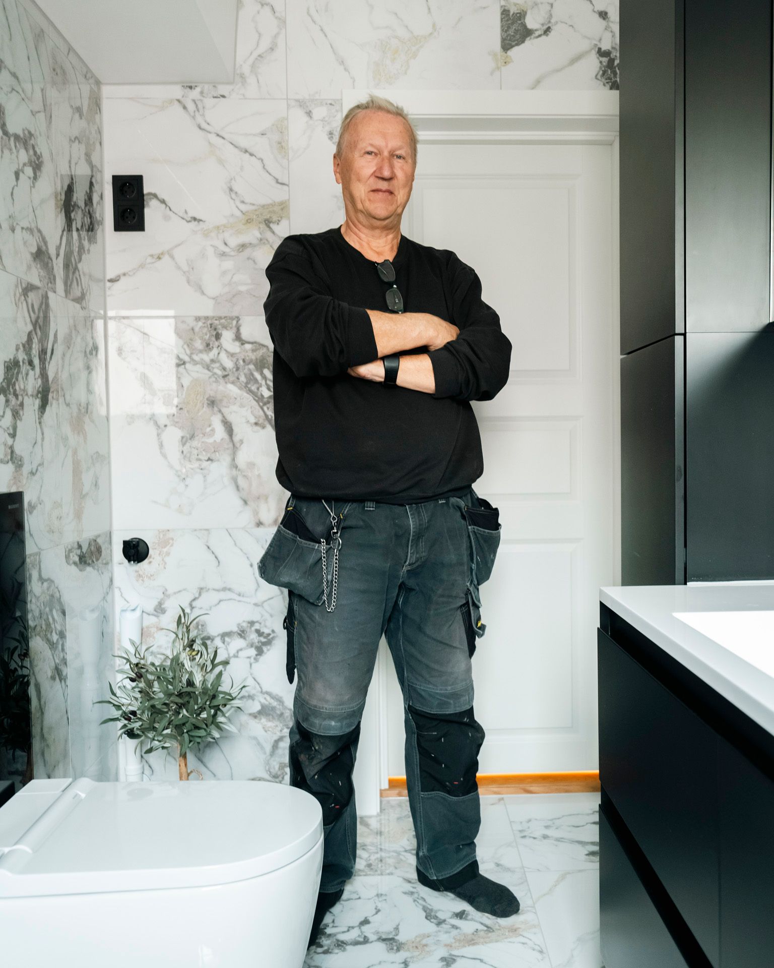 Vaktmester og beboer Tor Arne Adamsen på sitt nyoppussede bad med marmorliknende fliser.